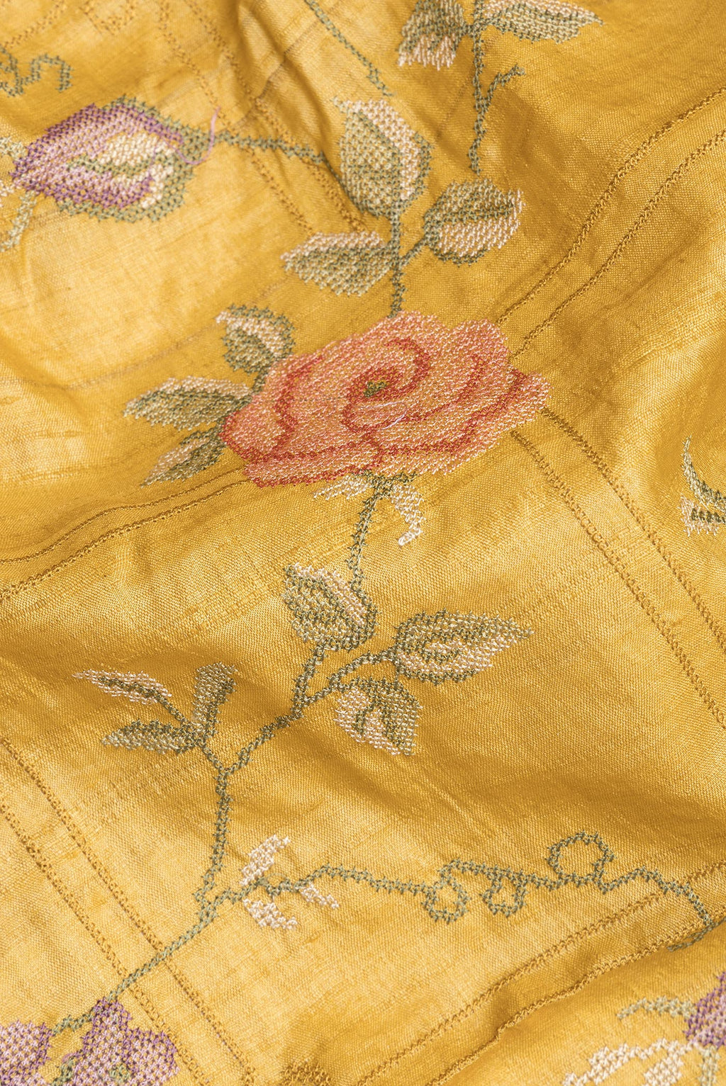 Close up of Mustard Tussar Saree with Embroidery on the body and Embroidery Border.  displaying folds