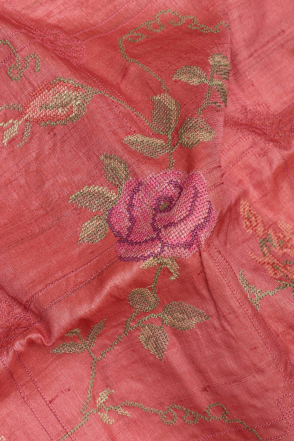 Close up of Coral Tussar Saree with Embroidery on the body and Embroidery Border.  displaying folds