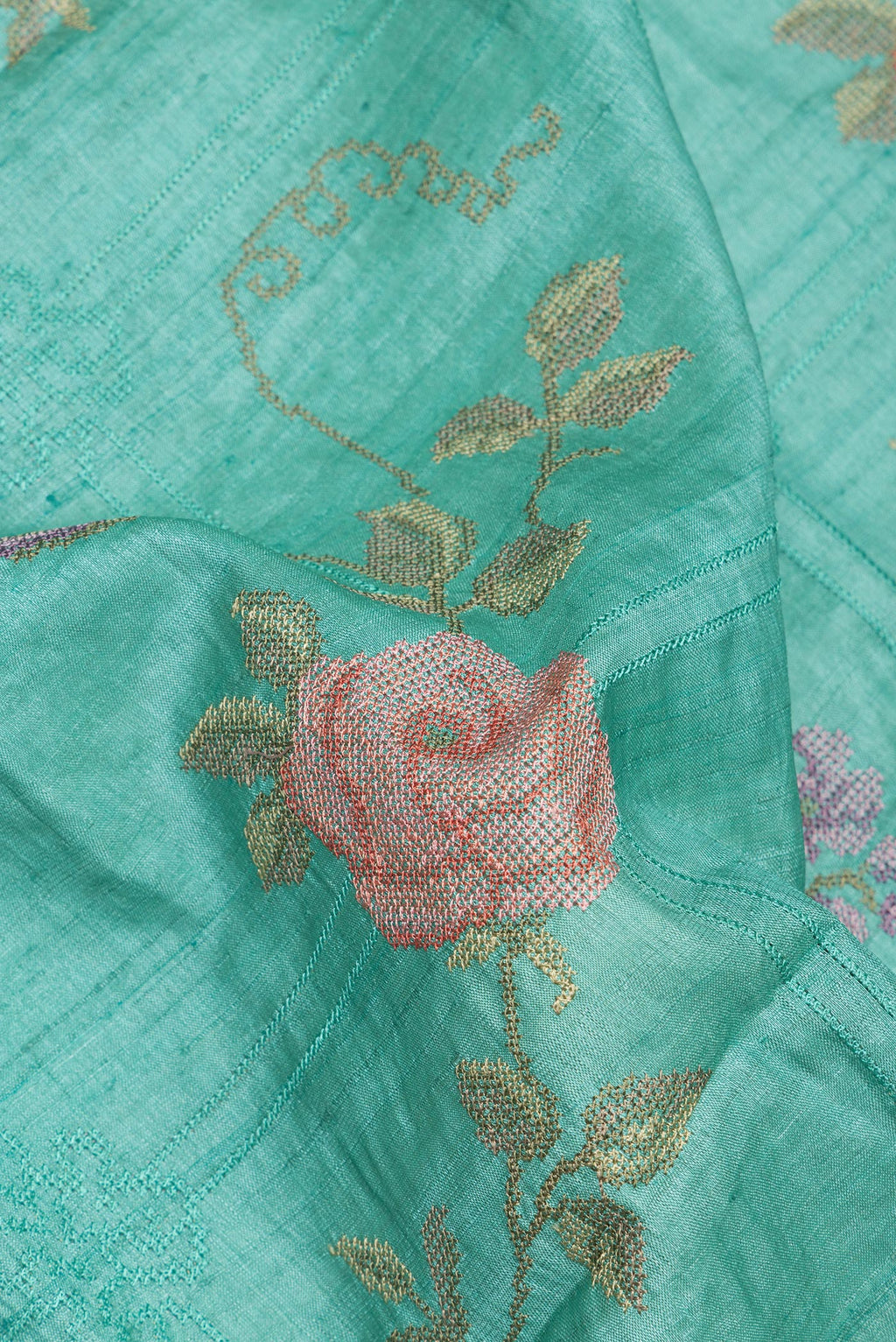 Close up of Sea Green Tussar Saree with Embroidery on the body and Embroidery Border.  displaying folds