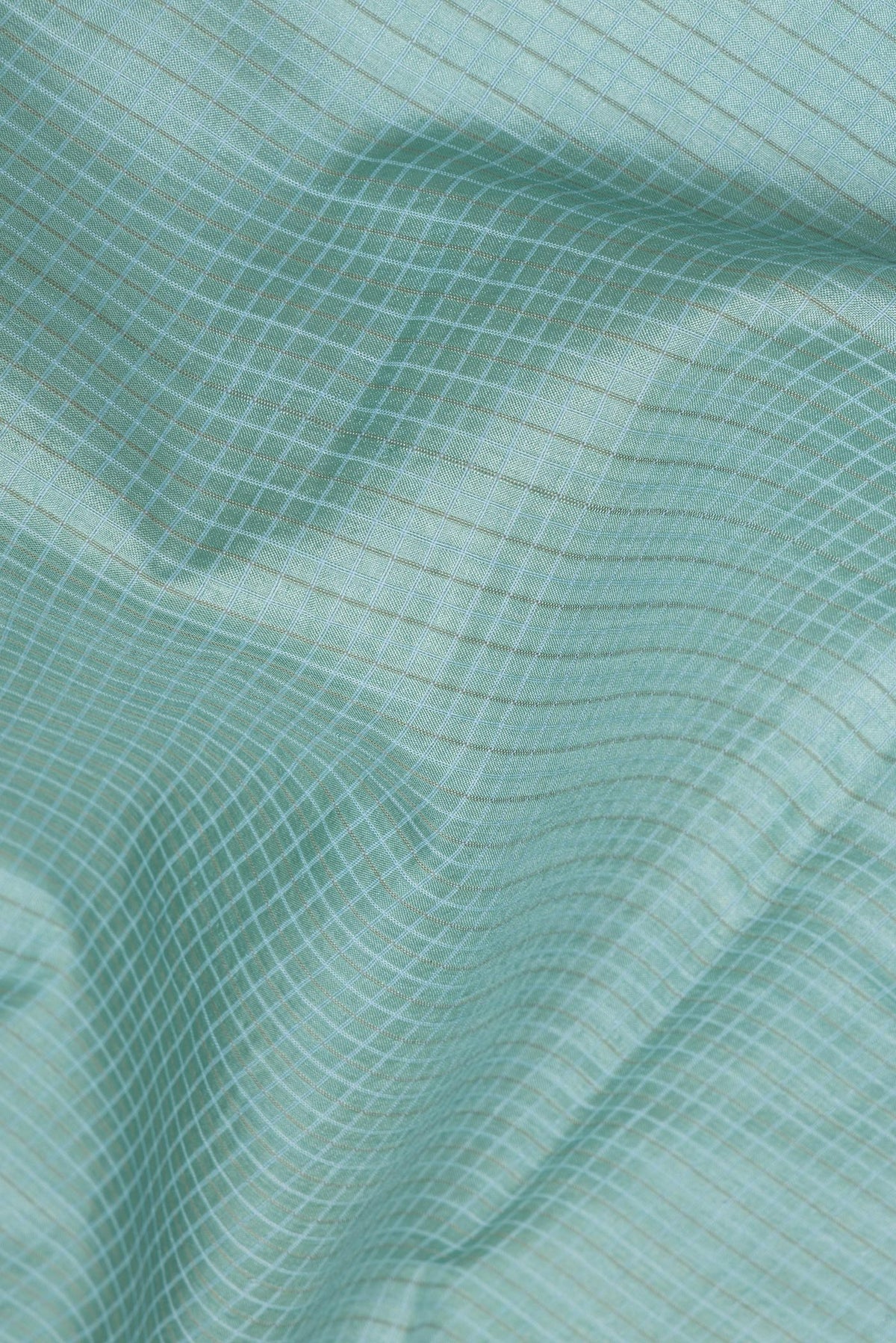 Close up of Sky Blue Tussar Saree with Checked design on the body and Embroidery Border.  displaying folds