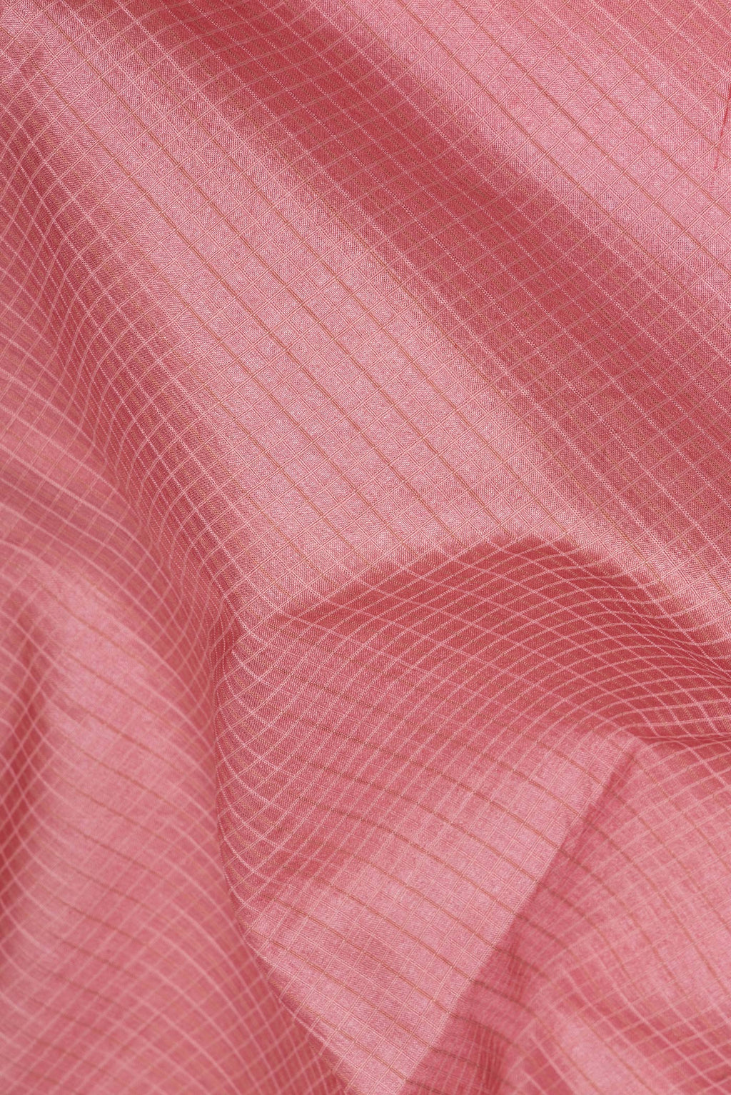 Close up of Peach Tussar Saree with Checked design on the body and Embroidery Border.  displaying folds