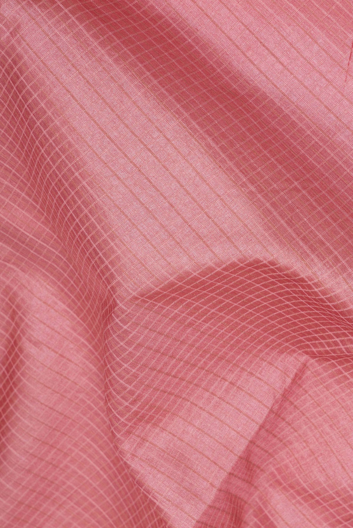 Close up of Peach Tussar Saree with Checked design on the body and Embroidery Border.  displaying folds