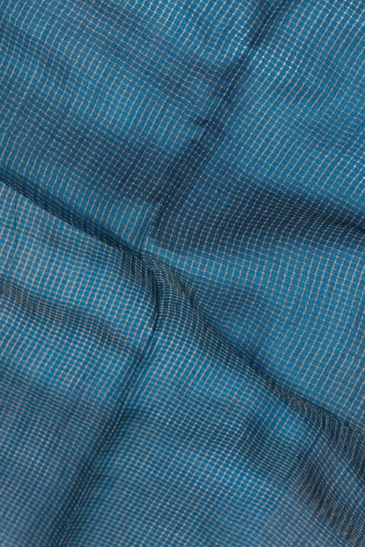 Close up of Peacock Blue Tussar Saree with Checked design on the body and Embroidery Border.  displaying folds