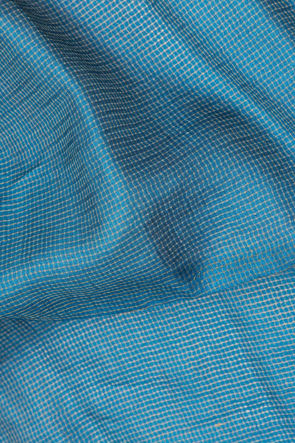 Close up of Pure Silk Peacock Blue Dual Tone Tussar Saree with Checked design on the body and Embroidery Border.  displaying folds