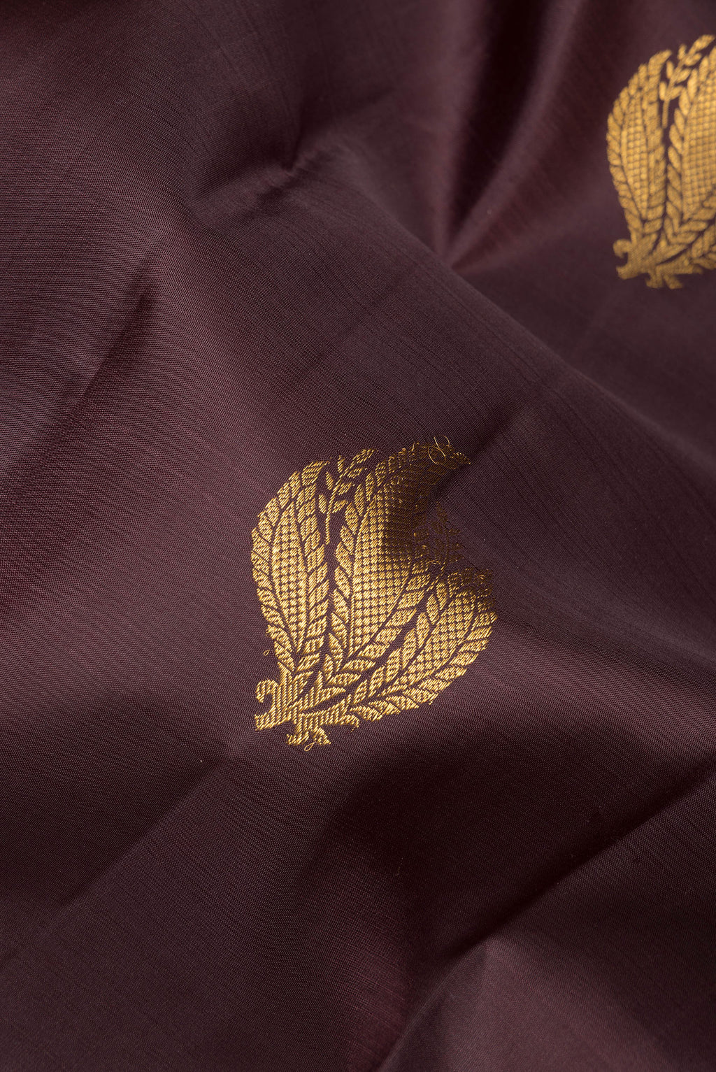 Close up of Pure Silk Coffee Brown Kanchipuram Saree with Zari Butta on the body and Fancy Border.  displaying folds
