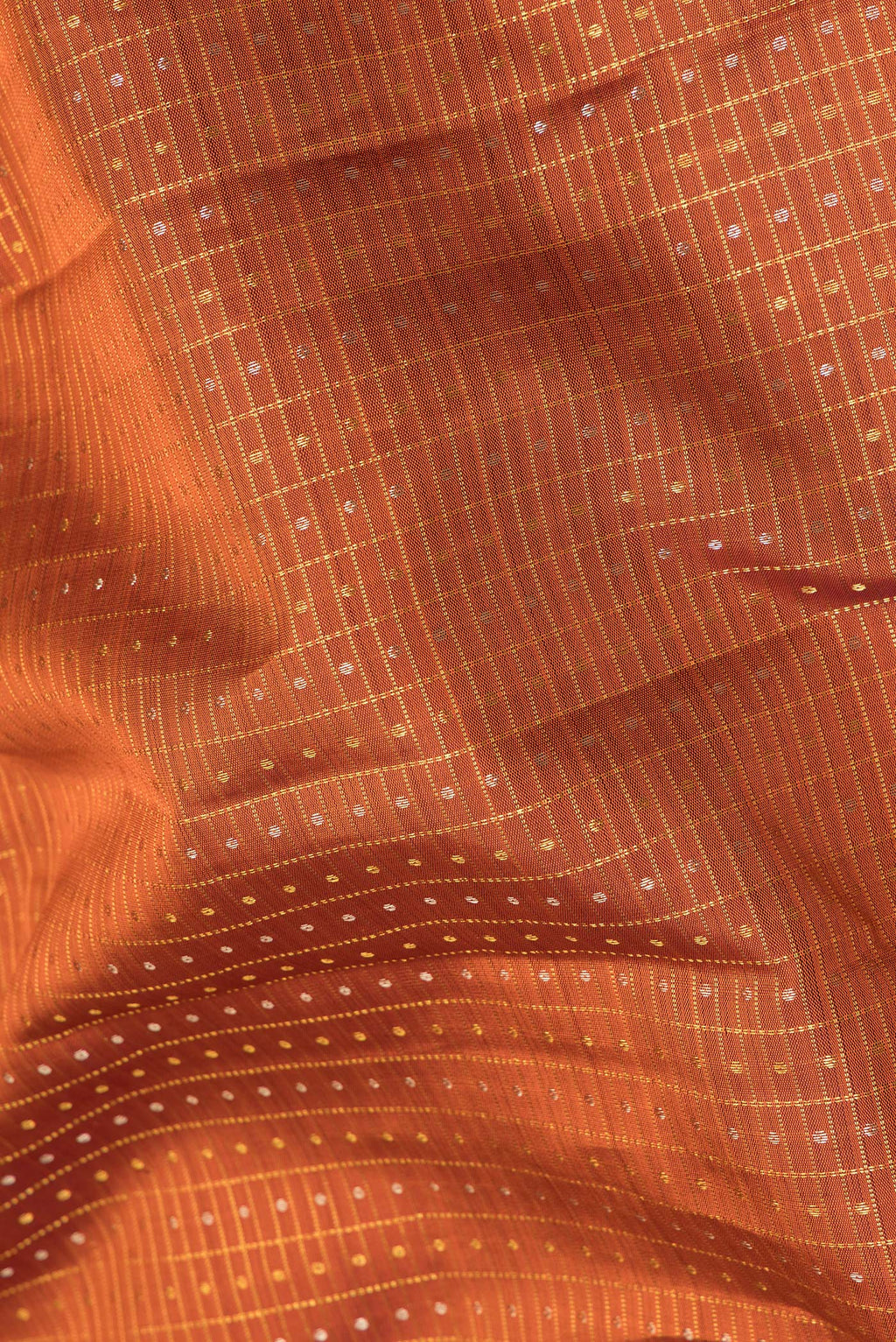 Close up of Pure Silk Orange Kanjivaram Saree with Checked design on the body and Zari Border.  displaying folds