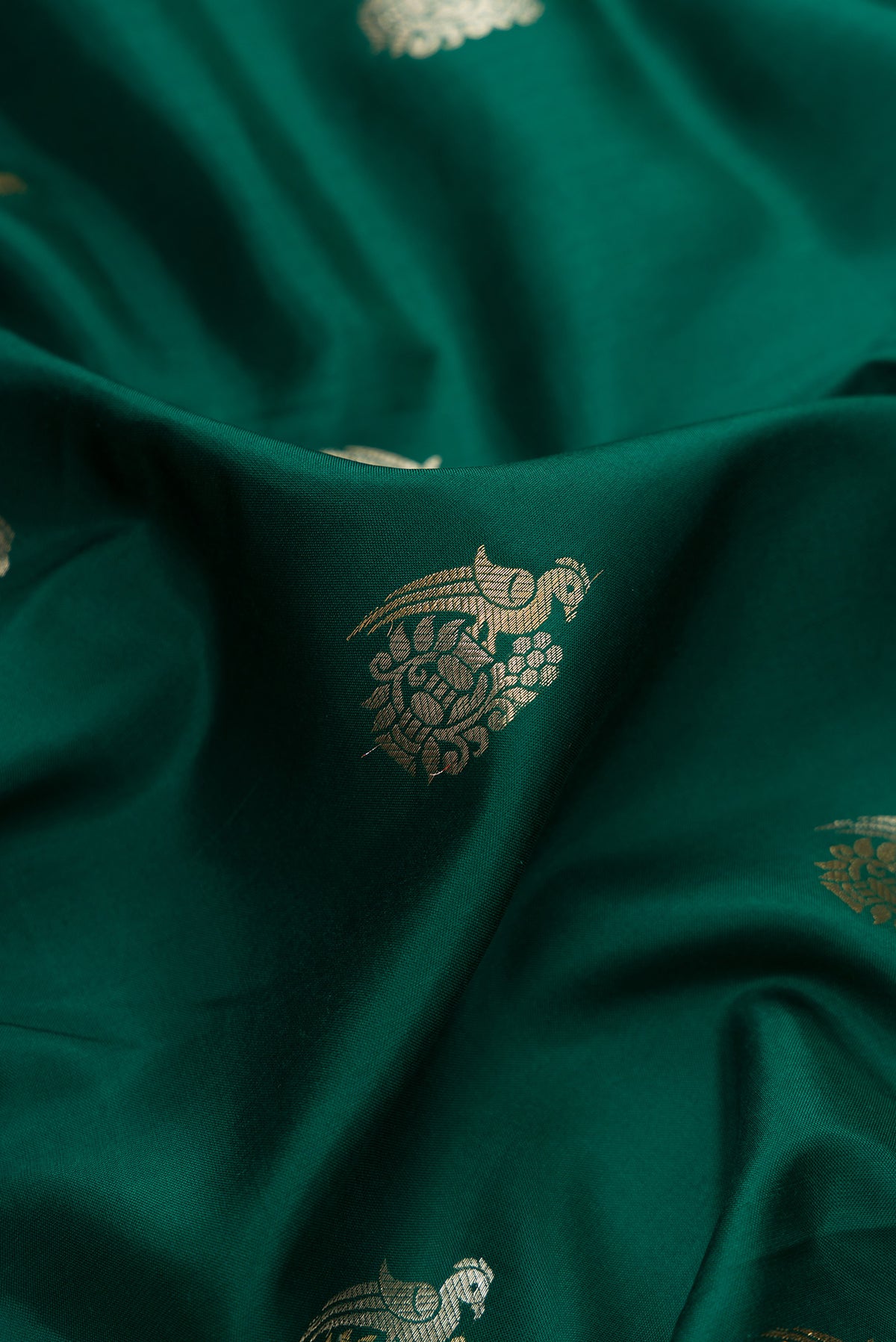 Close up of Pure Silk Green Kanjivaram Saree with Zari Butta on the body and Fancy Border.  displaying folds
