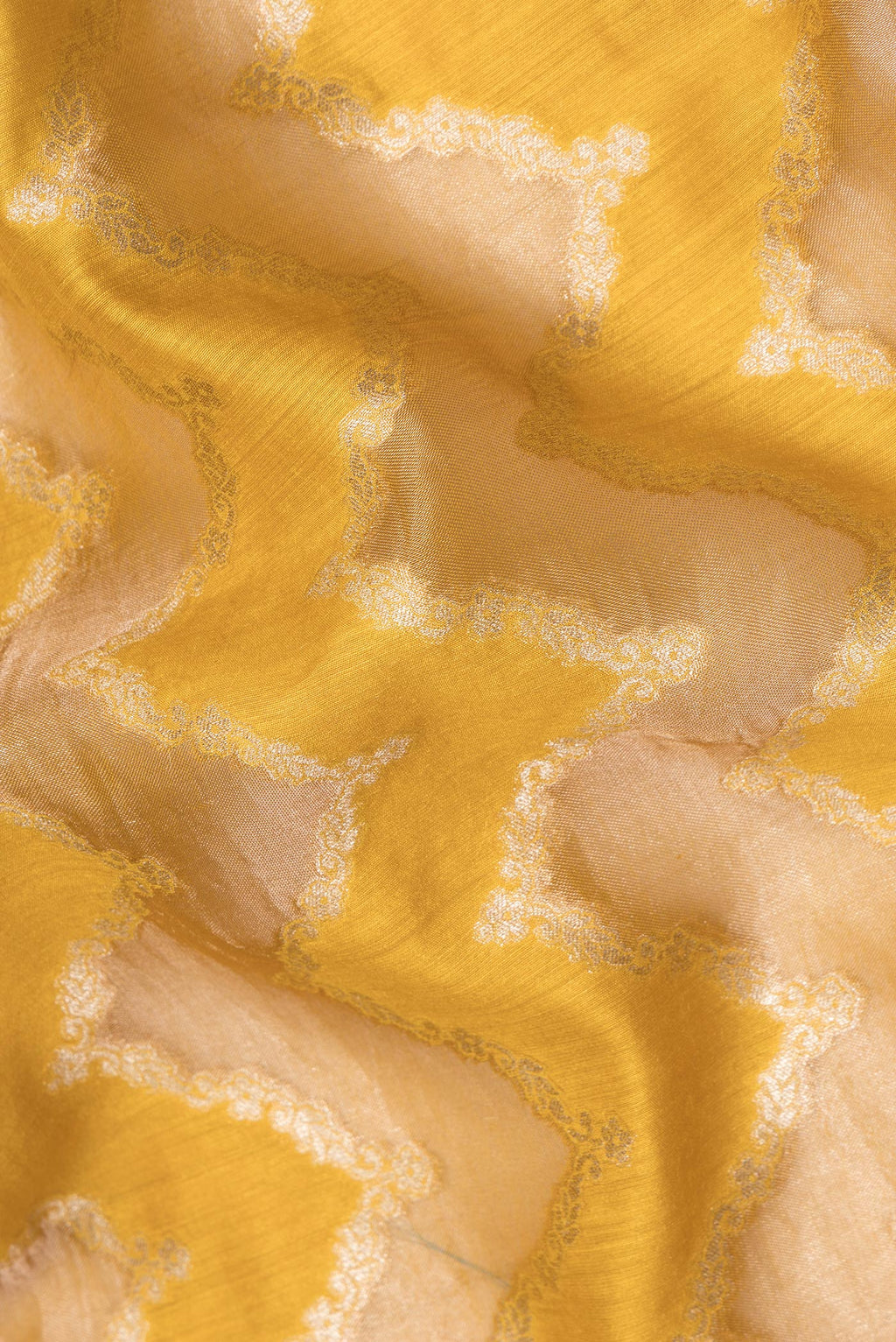 Close up of Pure Silk Mustard Dual Tone Tussar Saree with Zari Brocade on the body and Embroidery Border.  displaying folds