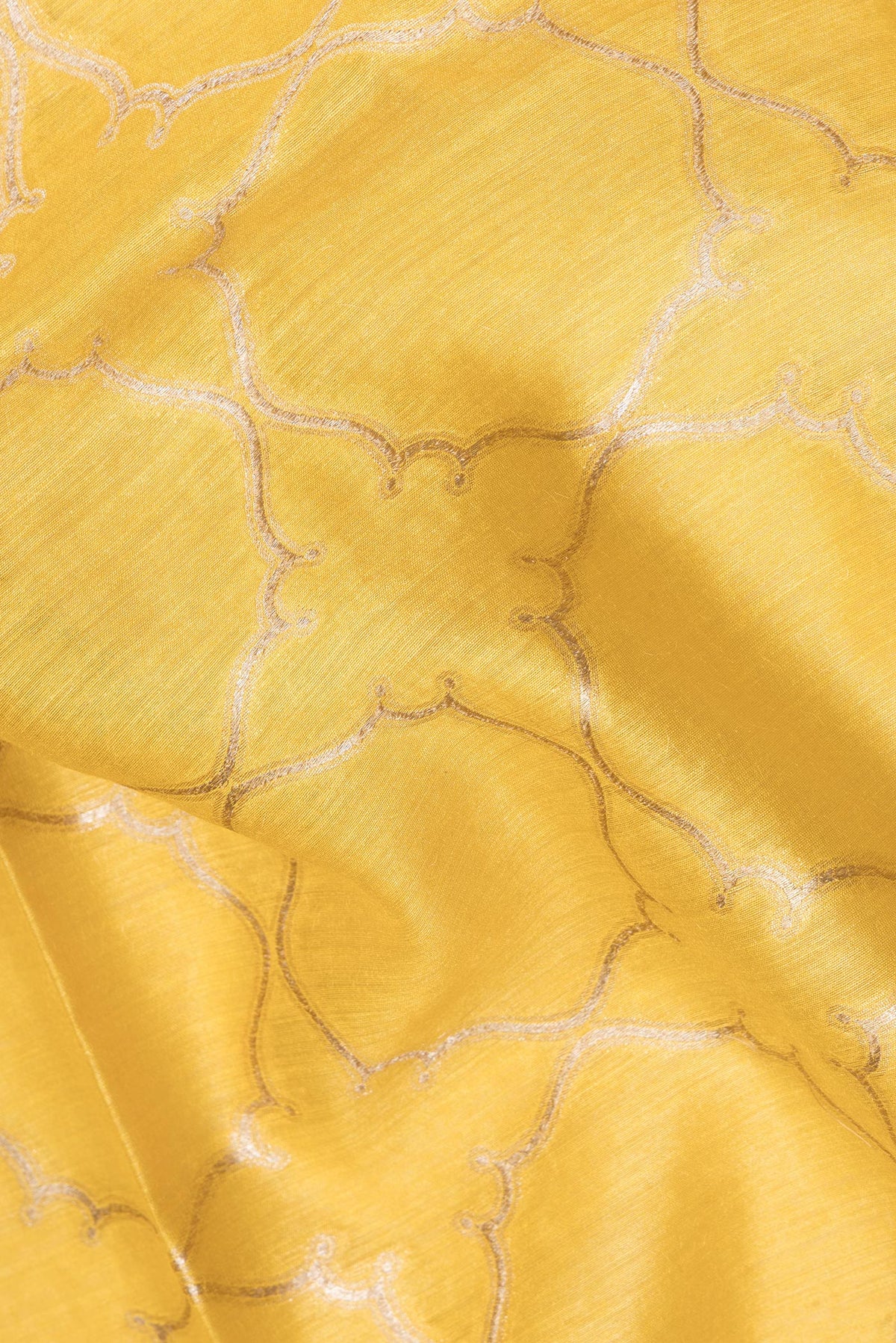 Close up of Pure Silk Yellow Dual Tone Tussar Saree with Zari Brocade on the body and Embroidery Border.  displaying folds