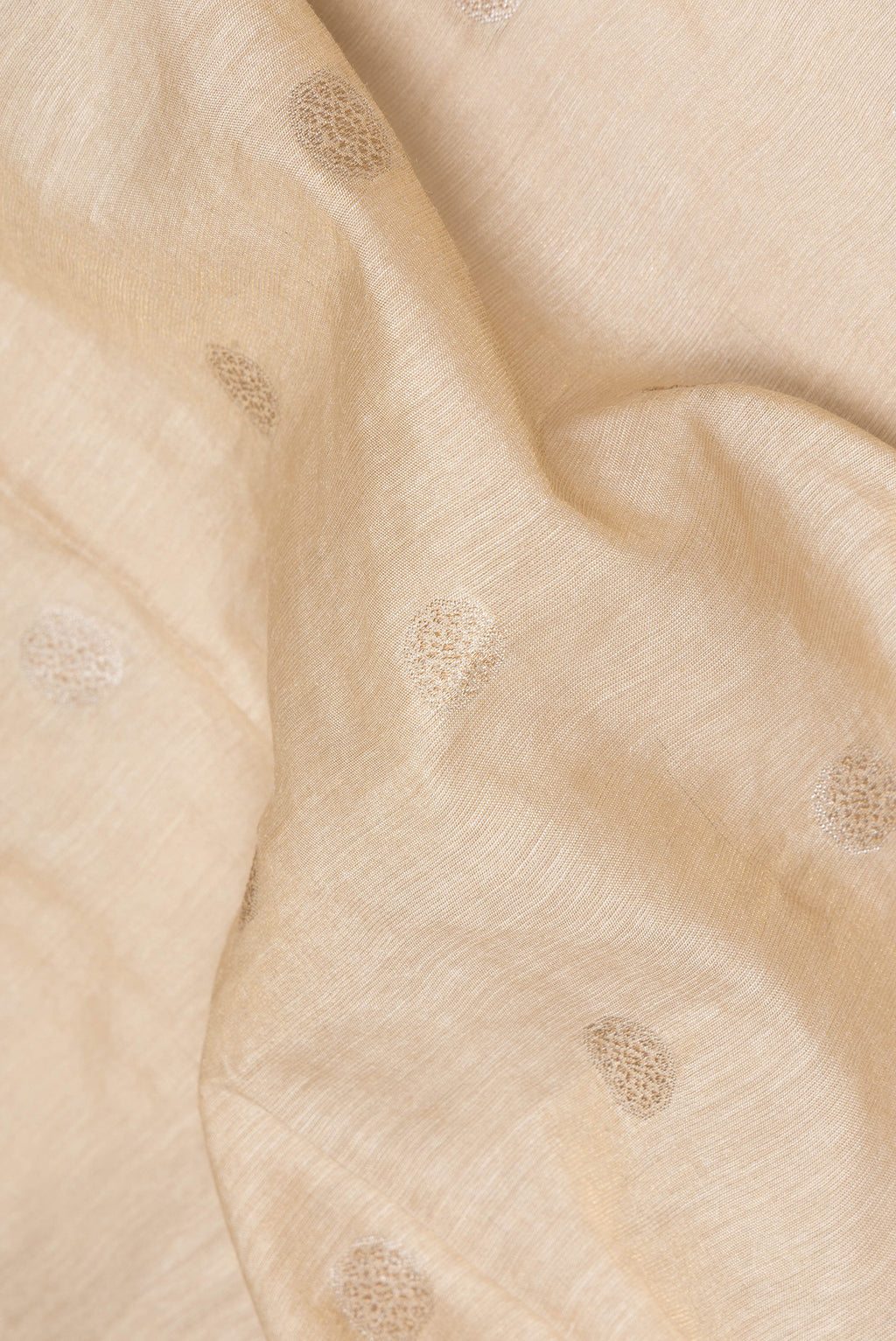 Close up of Pure Silk Beige Tussar Saree with Thread Butta on the body and Embroidery Border.  displaying folds