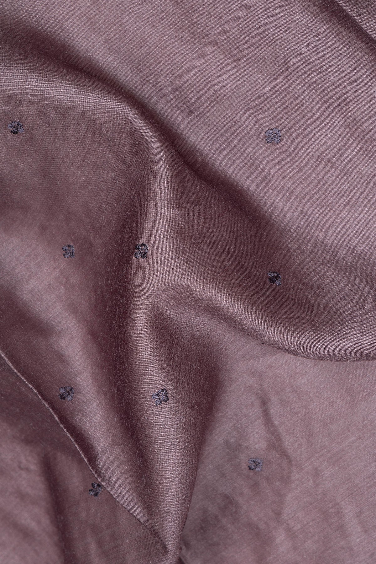 Close up of Brown Tussar Saree with Embroidery on the body and Embroidery Border.  displaying folds