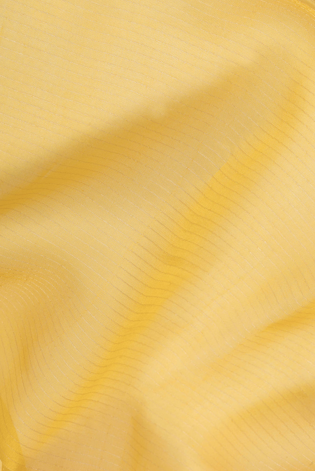 Close up of Pure Silk Yellow Dual Tone Tussar Saree with Stripes on the body and Embroidery Border.  displaying folds