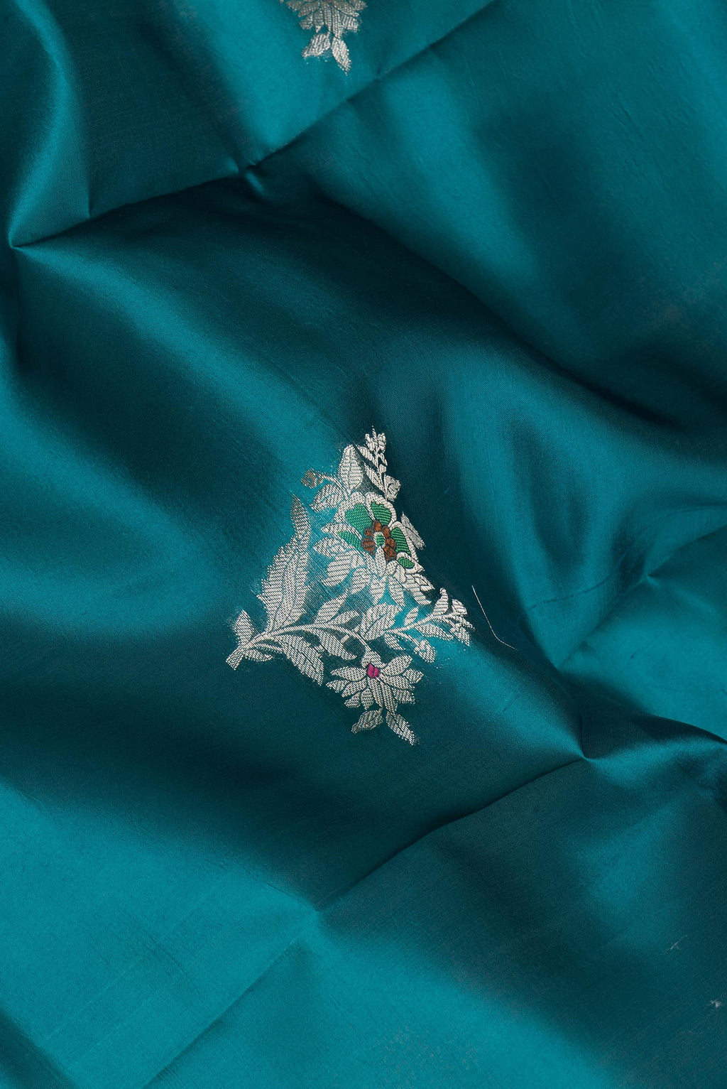 Close up of Pure Silk Peacock Blue Dual Tone Tussar Saree with Zari Butta on the body and Fancy Border.  displaying folds