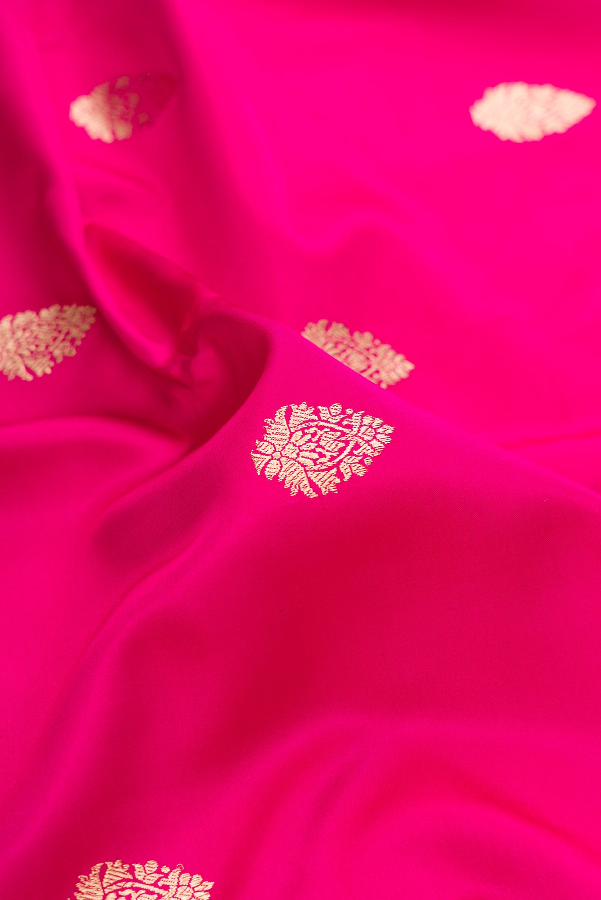 Close up of Pure Silk Pink Banarasi Saree with Zari Butta on the body and Zari Border.  displaying folds