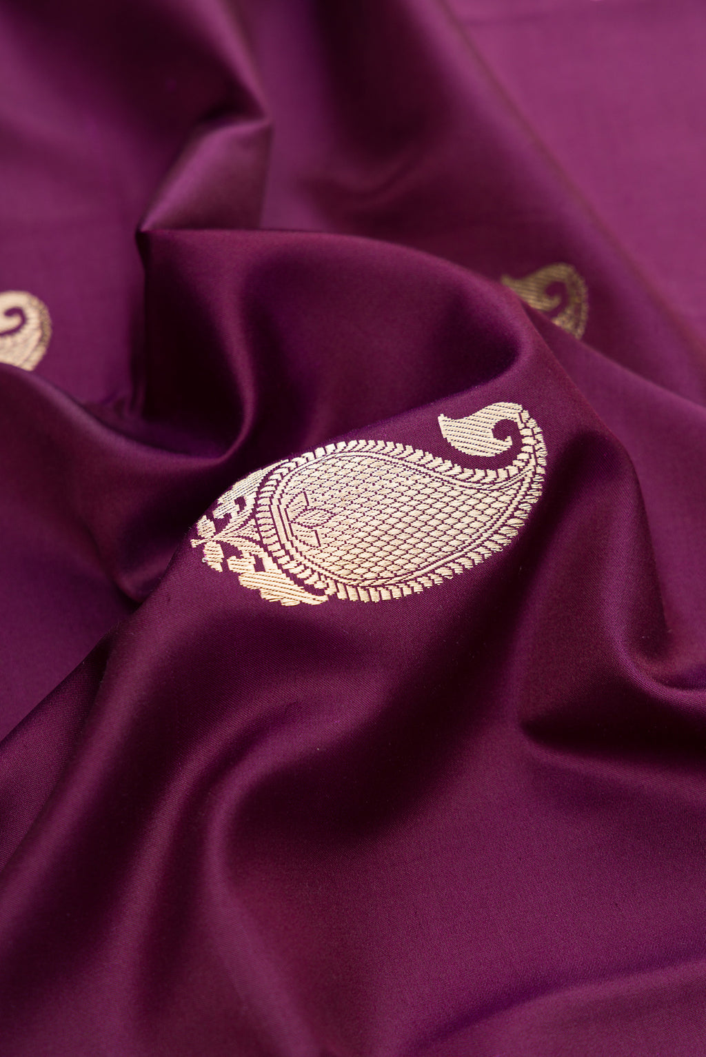 Close up of Pure Silk Burgundy Banarasi Saree with Zari Butta on the body and Zari Border.  displaying folds
