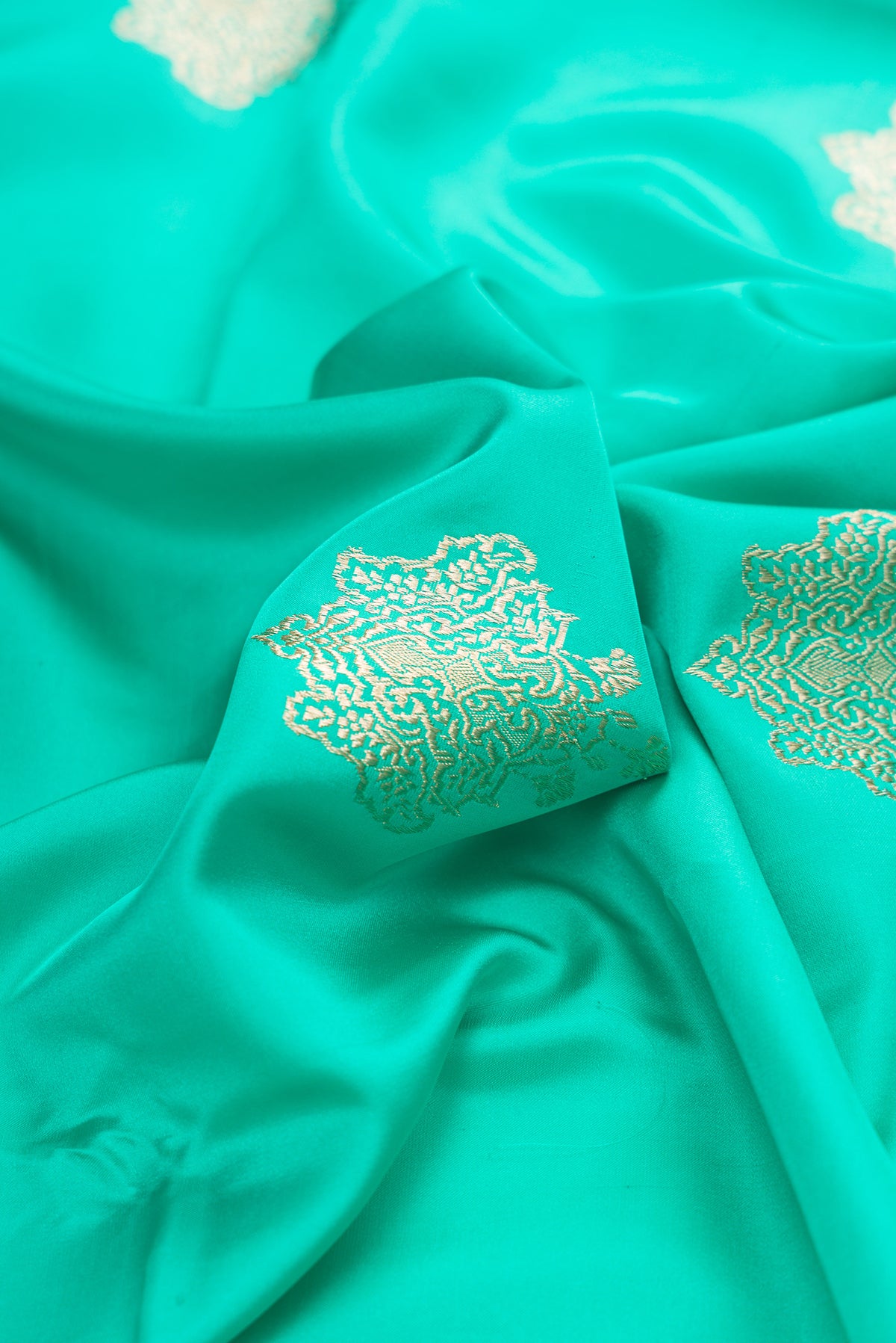 Close up of Pure Silk Sea Green Banarasi Saree with Zari Butta on the body and Zari Border.  displaying folds