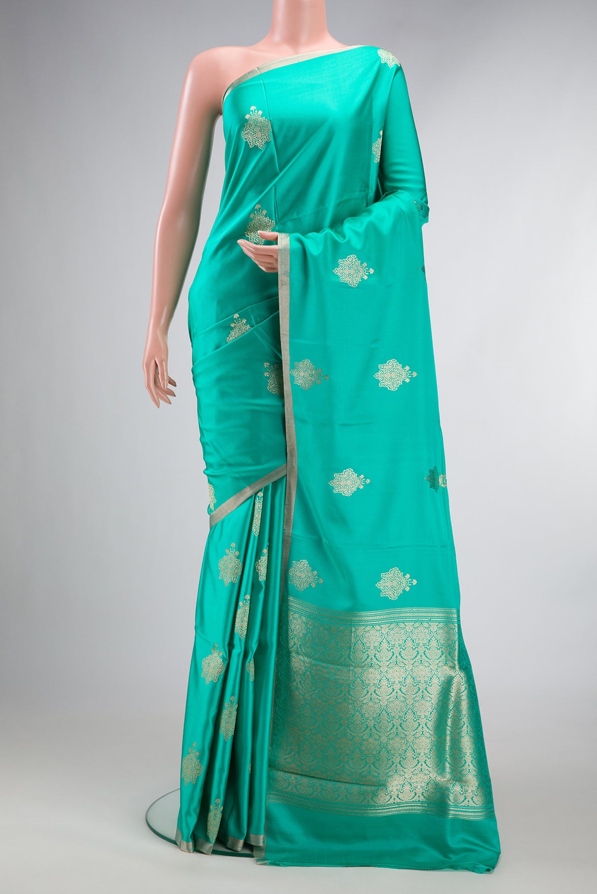 Pure Silk Sea Green Banarasi Saree with Zari Butta on the body and Zari Border.  displayed on a mannequin