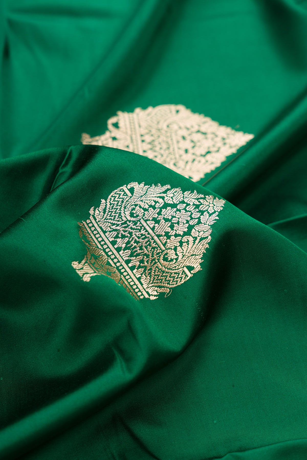 Close up of Pure Silk Green Banarasi Saree with Zari Butta on the body and Zari Border.  displaying folds