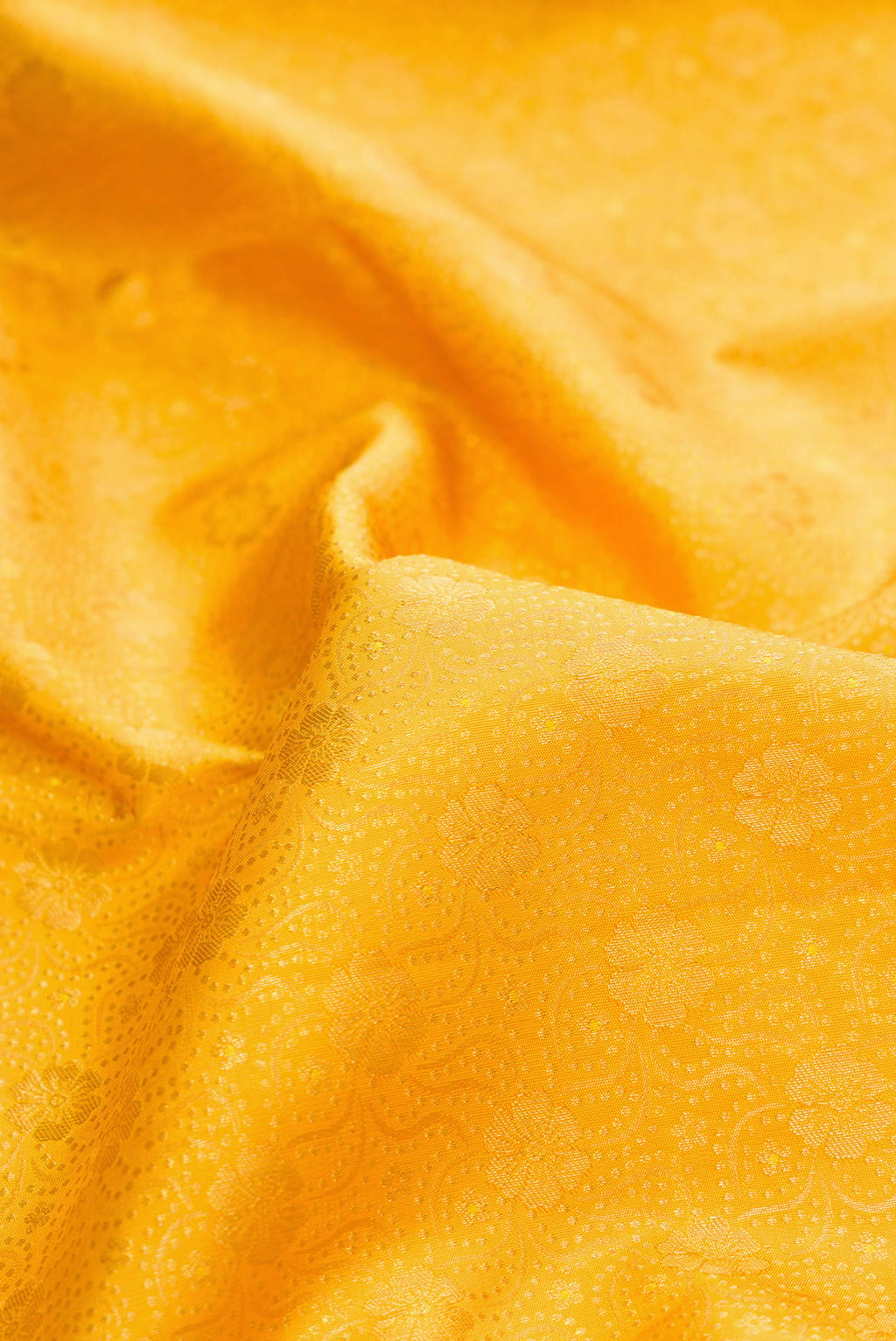 Close up of Pure Silk Mustard Kanchipuram Saree with Zari Brocade on the body and Zari Border.  displaying folds