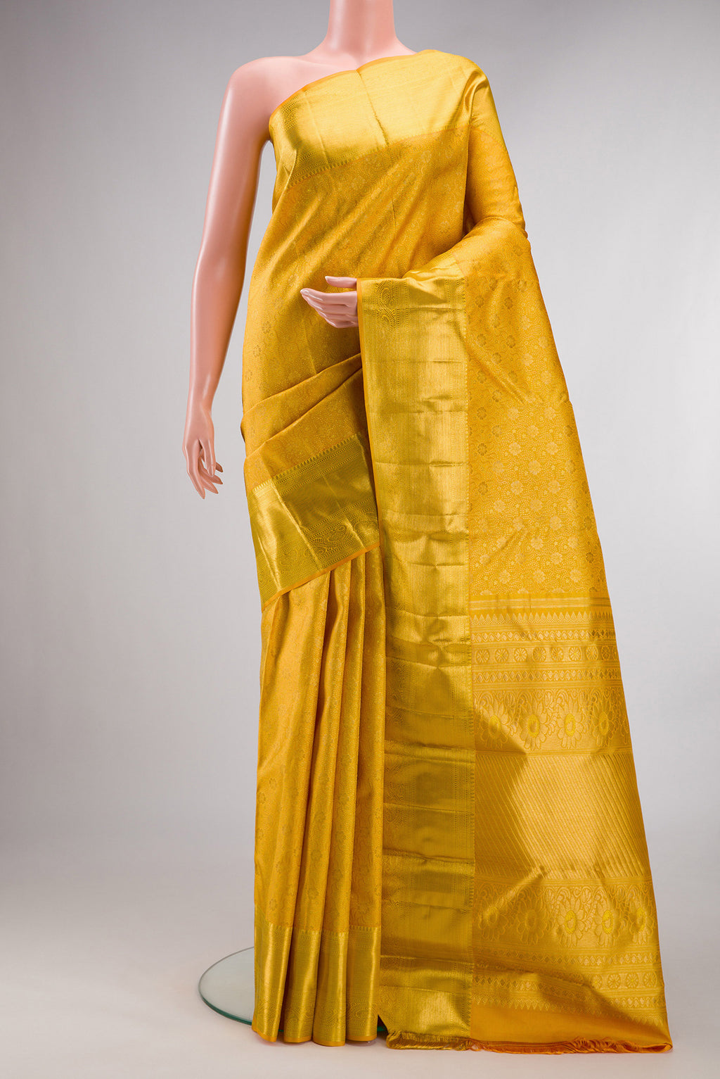 Pure Silk Mustard Kanchipuram Saree with Zari Brocade on the body and Zari Border.  displayed on a mannequin