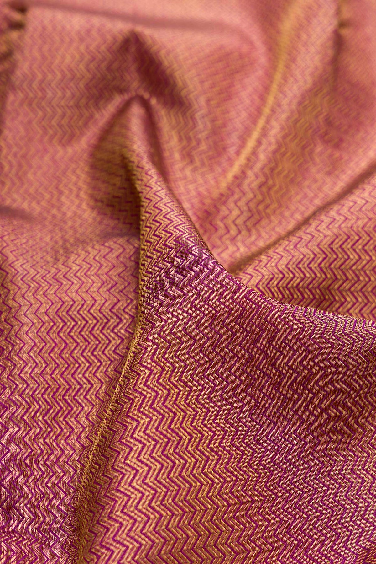 Close up of Pure Silk Magenta Kanchipuram Saree with Zari Brocade on the body and Zari Border.  displaying folds