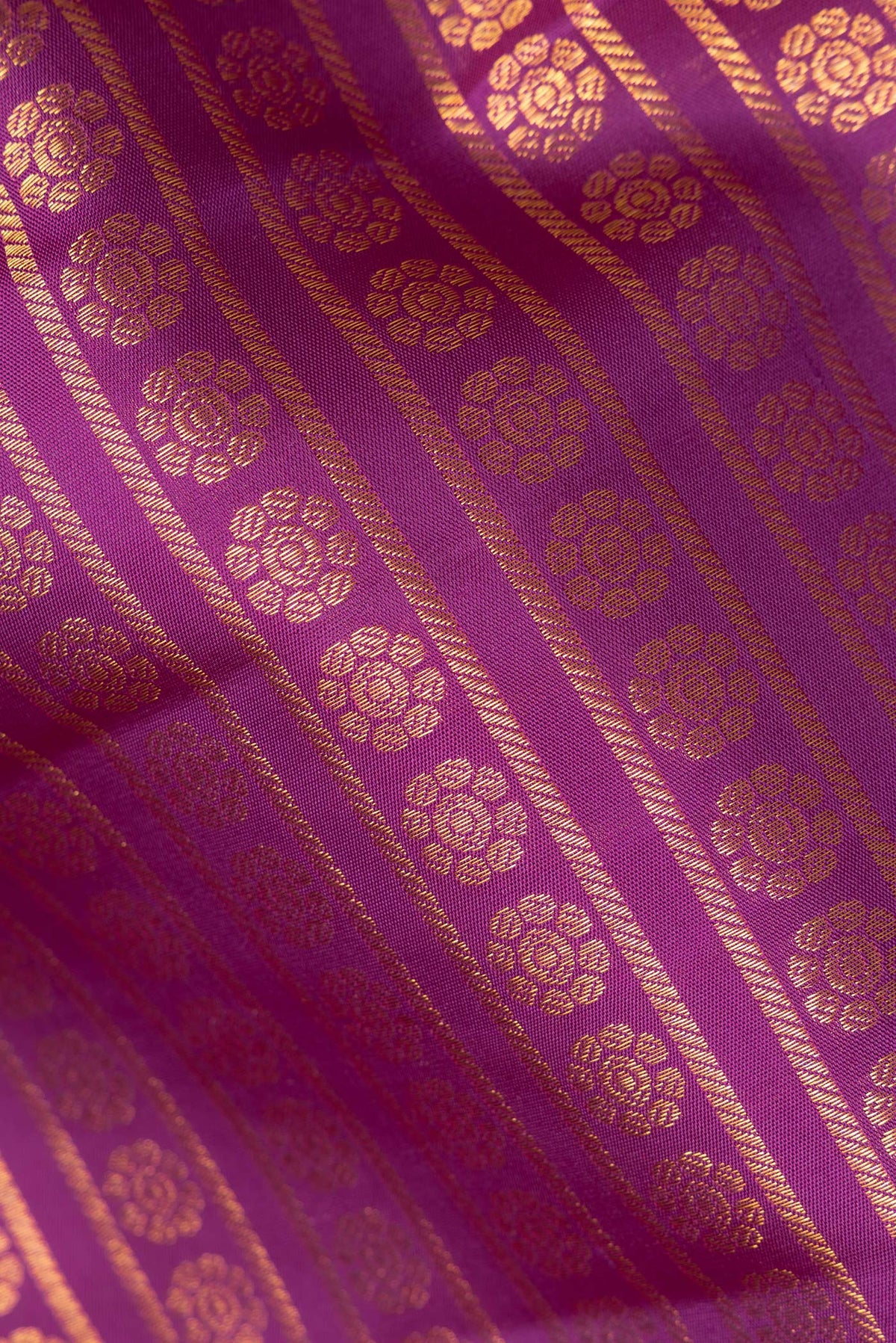 Close up of Pure Silk Magenta Kanchipuram Saree with Zari Butta on the body and Zari Border.  displaying folds