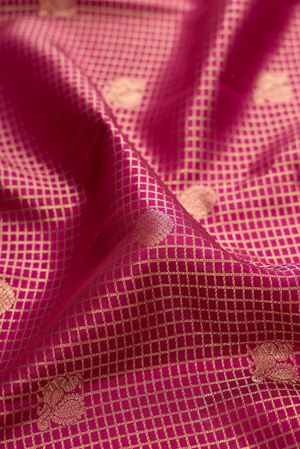 Close up of Pure Silk Dark Pink Kanjivaram Saree with Zari Brocade on the body and Zari Border.  displaying folds