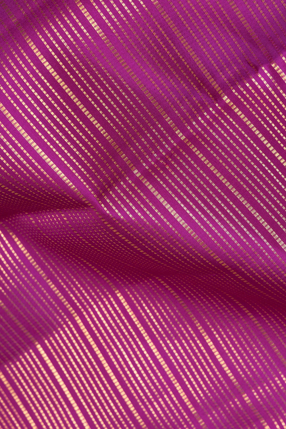 Close up of Pure Silk Magenta Kanjivaram Saree with Zari Brocade on the body and Fancy Border.  displaying folds