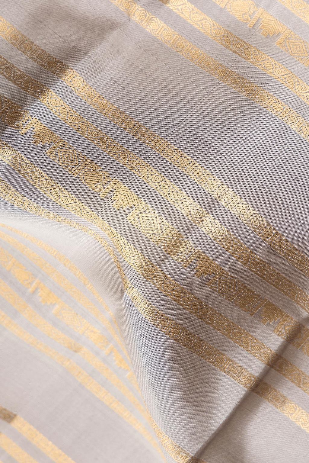 Close up of Pure Silk Grey Kanjivaram Saree with Stripes on the body and Fancy Border.  displaying folds