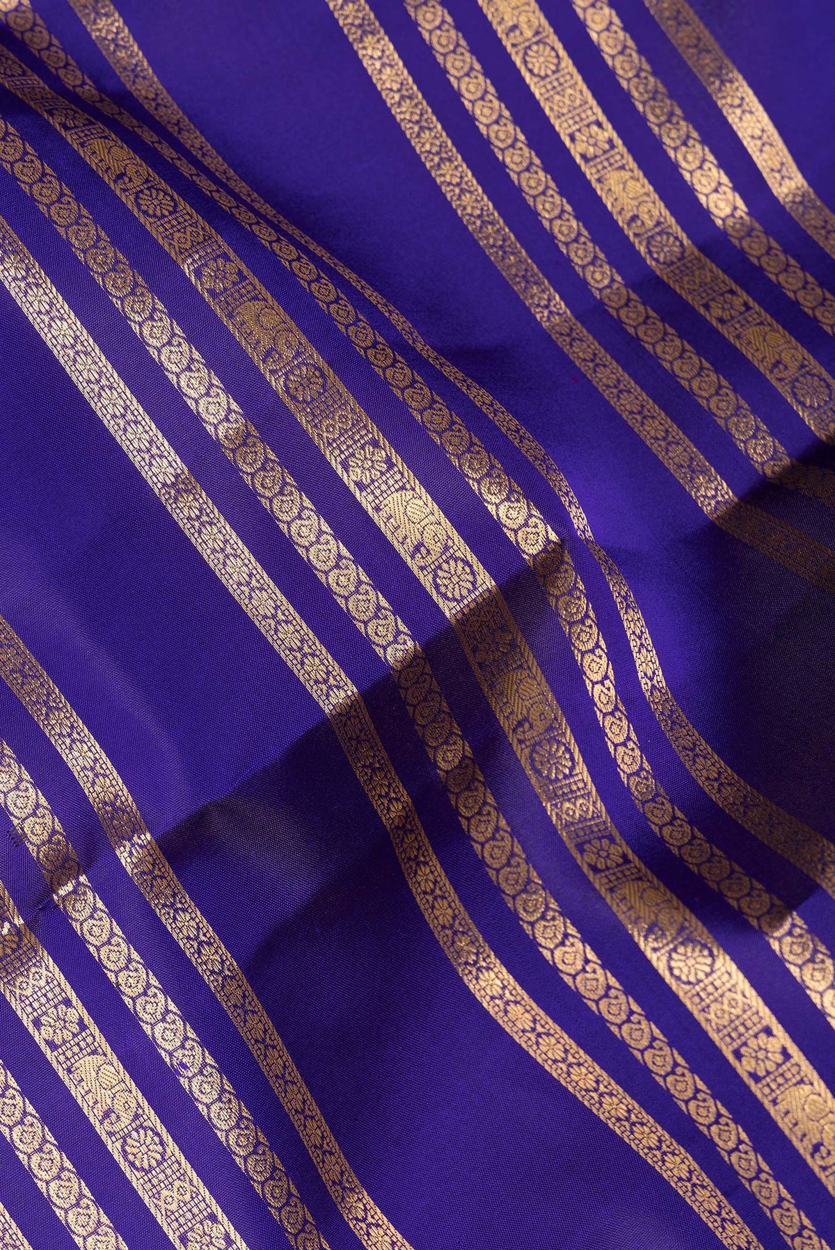 Close up of Pure Silk Royal Blue Kanjivaram Saree with Stripes on the body and Fancy Border.  displaying folds