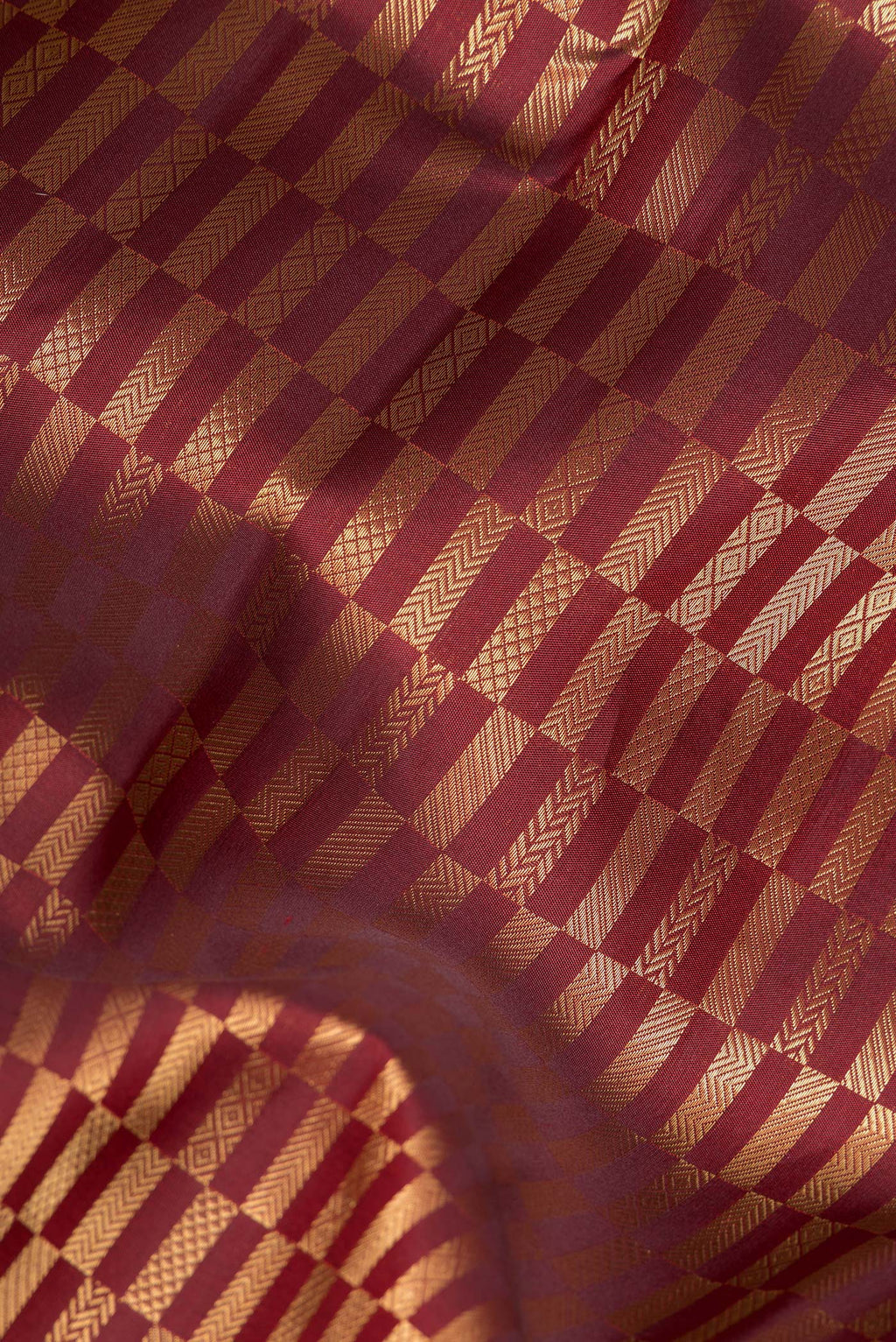 Close up of Pure Silk Maroon Kanjivaram Saree with Zari Brocade on the body and Zari Border.  displaying folds