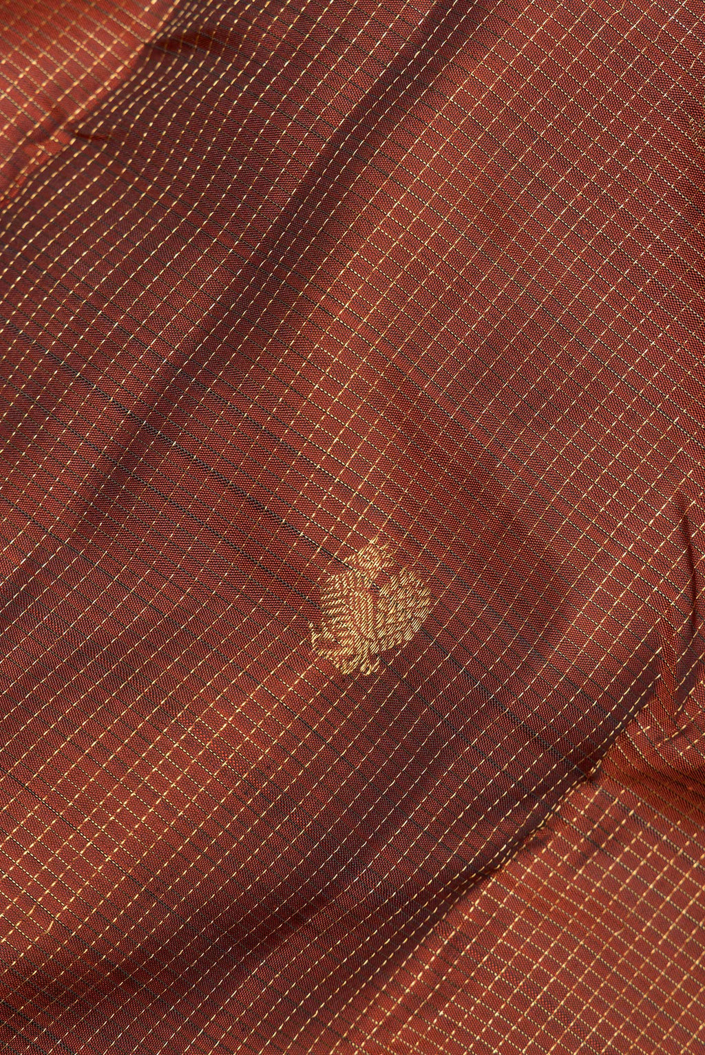Close up of Pure Silk Rust Kanjivaram Saree with Checked design on the body and Zari Border.  displaying folds