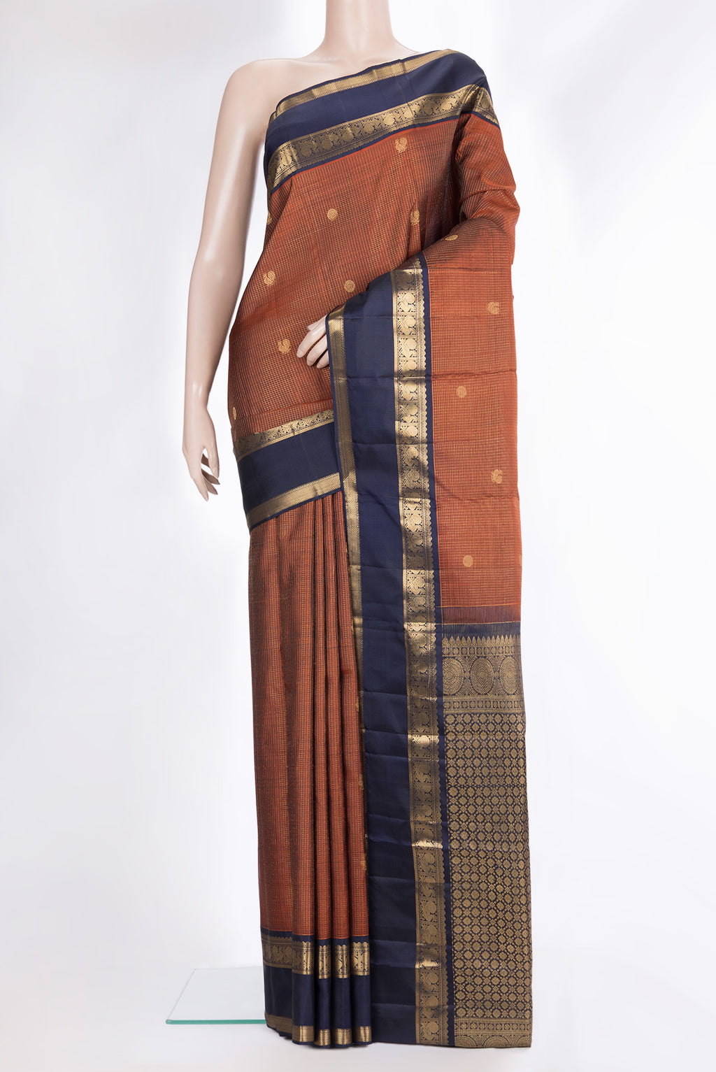 Pure Silk Rust Kanjivaram Saree with Checked design on the body and Zari Border.  displayed on a mannequin