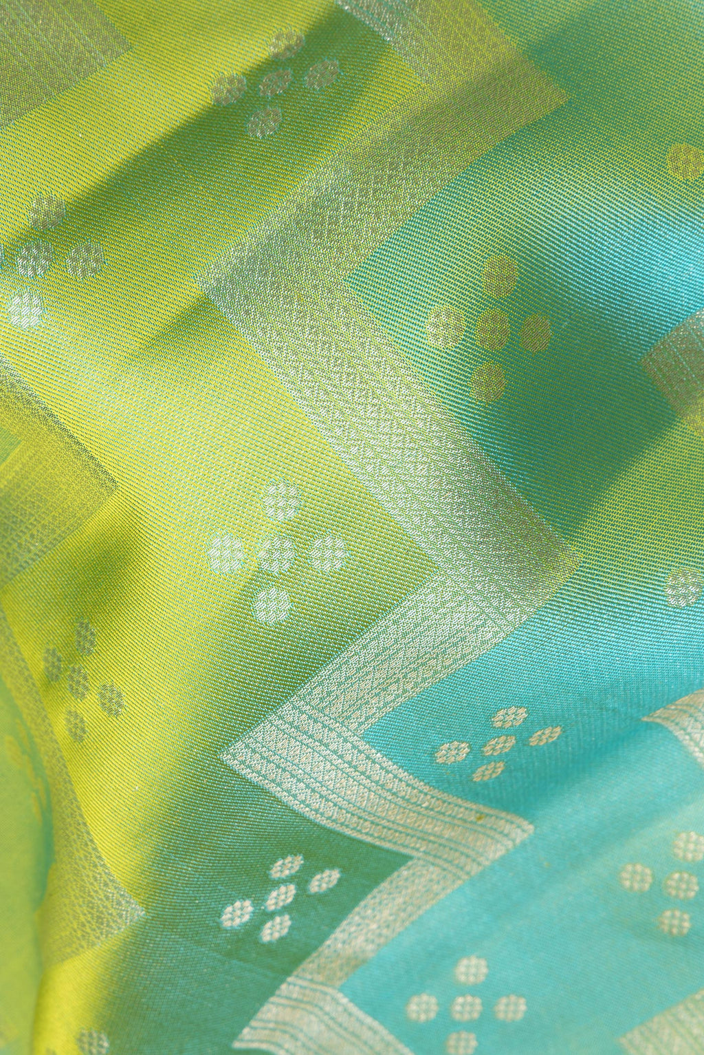 Close up of Pure Silk Green and Turquoise Color Kanjivaram Saree with Zari Brocade on the body and Zari Border.  displaying folds