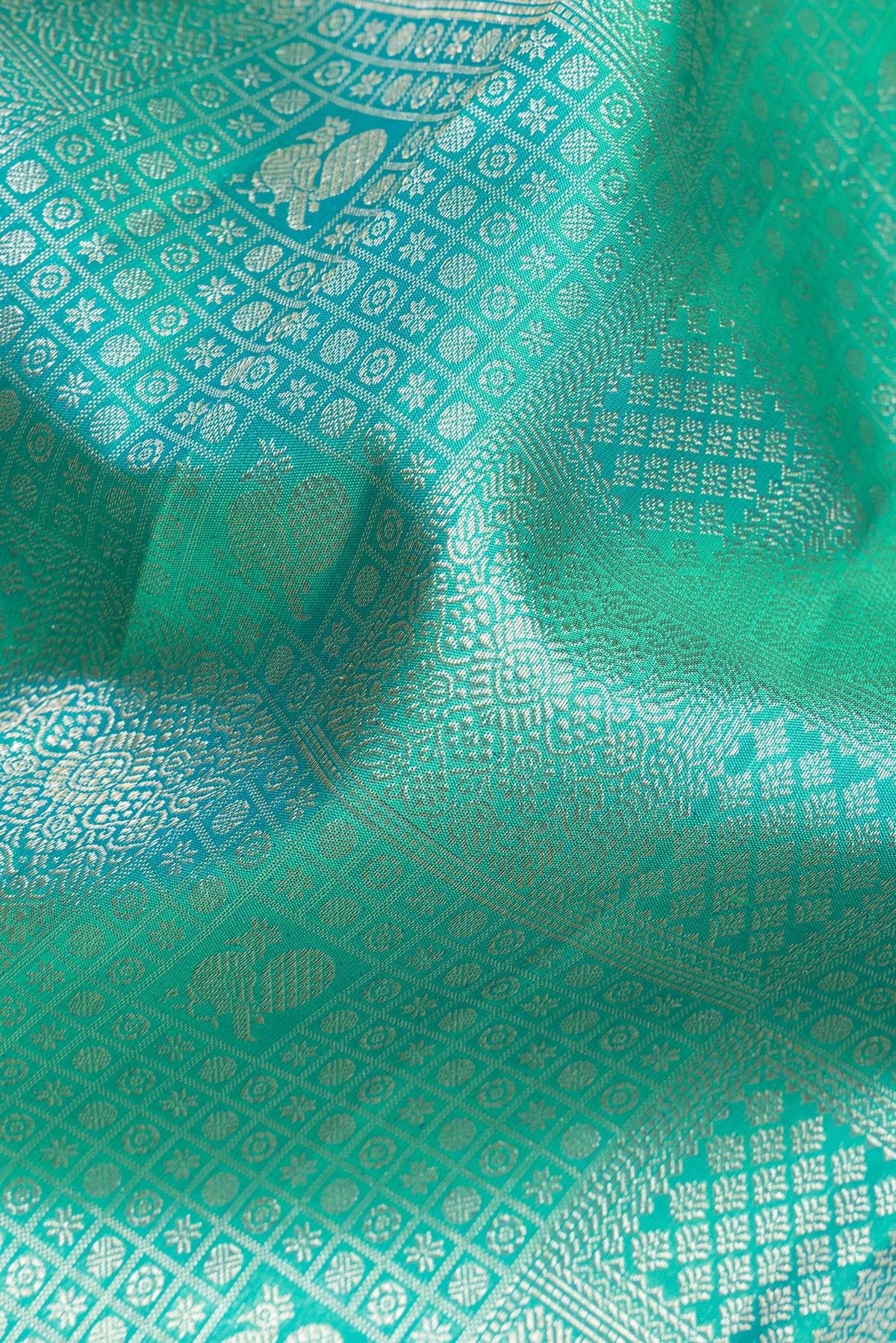 Close up of Pure Silk Sea Green Dual Tone Kanjivaram Saree with Zari Brocade on the body and Zari Border.  displaying folds