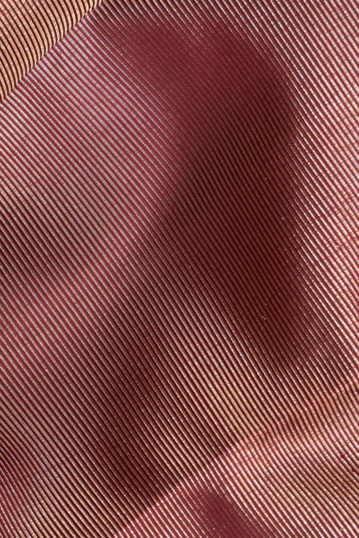 Close up of Pure Silk Maroon Kanjivaram Saree with Zari Brocade on the body and Fancy Border.  displaying folds