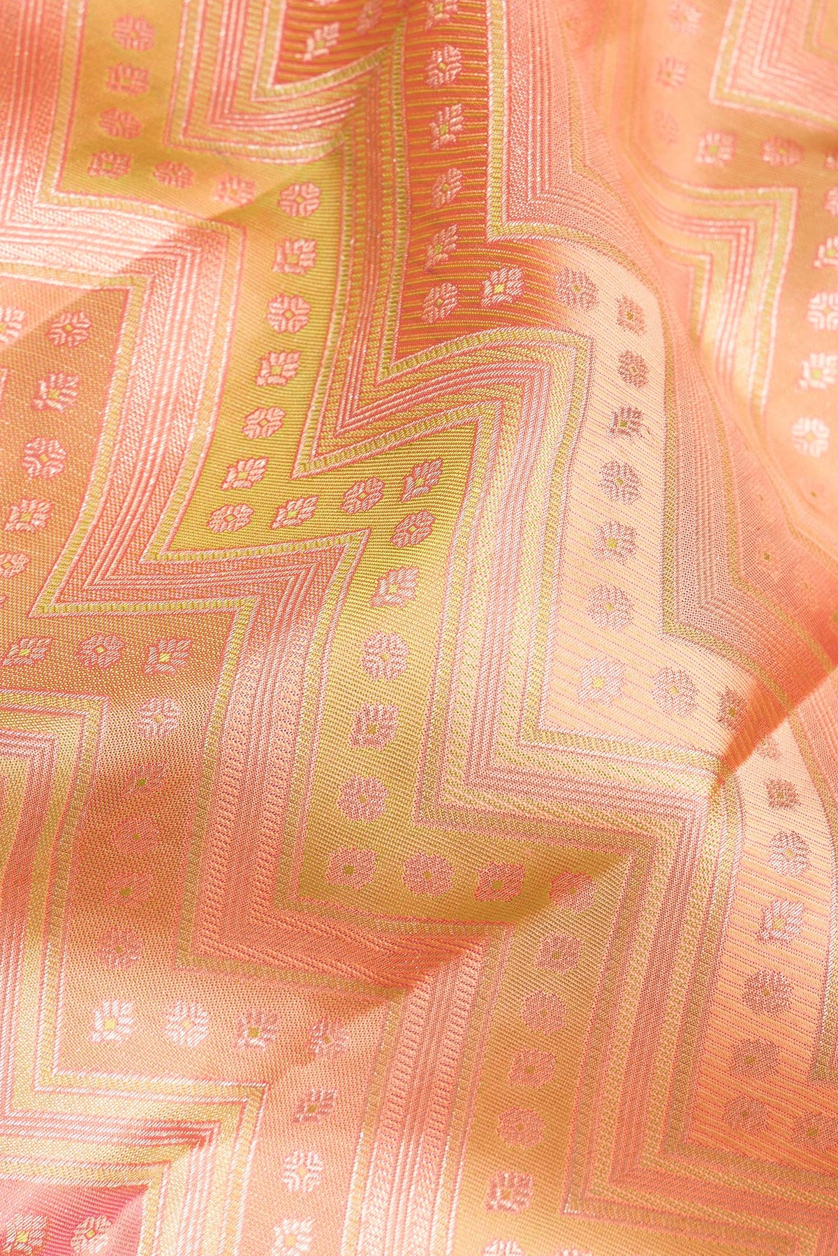 Close up of Pure Silk Peach Dual Tone Kanjivaram Saree with Zari Brocade on the body and Zari Border.  displaying folds