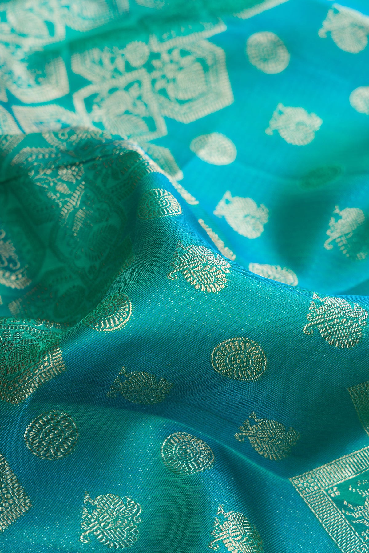 Close up of Pure Silk Blue and Sea Green Color Kanjivaram Saree with Zari Brocade on the body and Fancy Border.  displaying folds