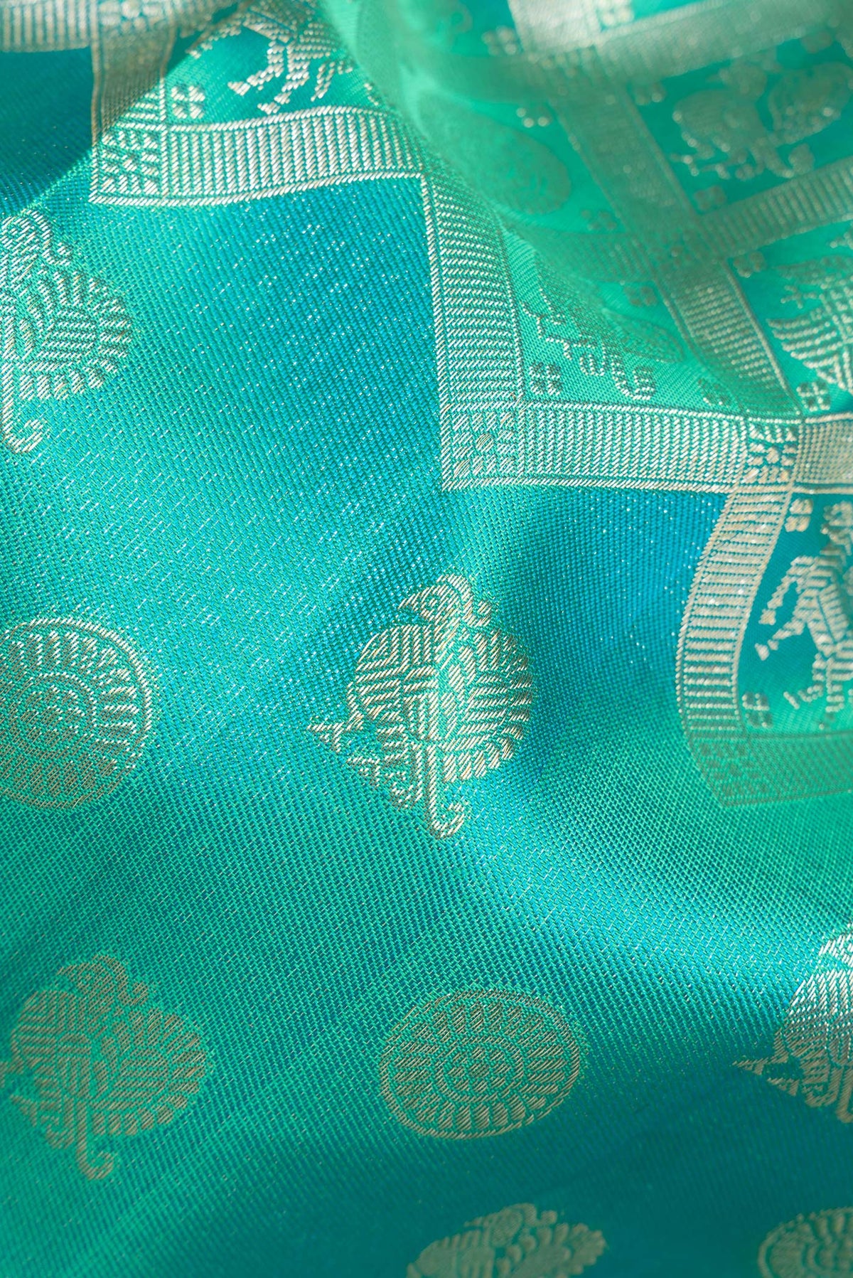 Close up of Pure Silk Sea Green Dual Tone Kanjivaram Saree with Zari Brocade on the body and Fancy Border.  displaying folds