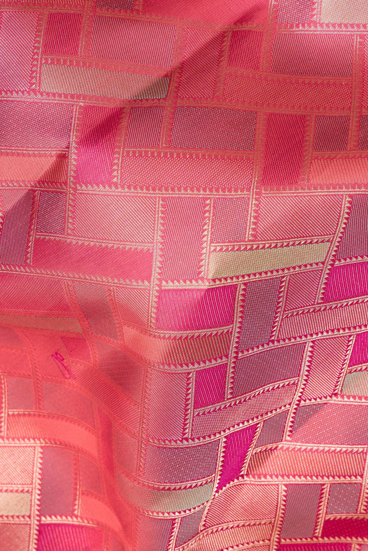 Close up of Pure Silk Coral Dual Tone Kanjivaram Saree with Zari Brocade on the body and Zari Border.  displaying folds