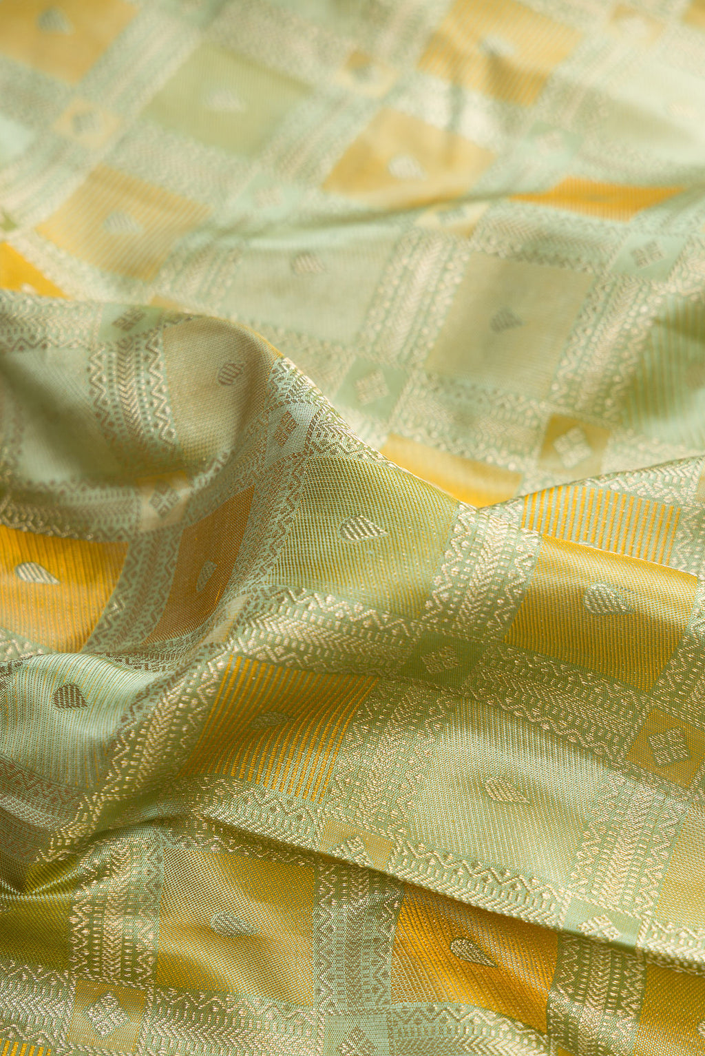 Close up of Pure Silk Pista Green Kanjivaram Saree with Zari Brocade on the body and Zari Border.  displaying folds