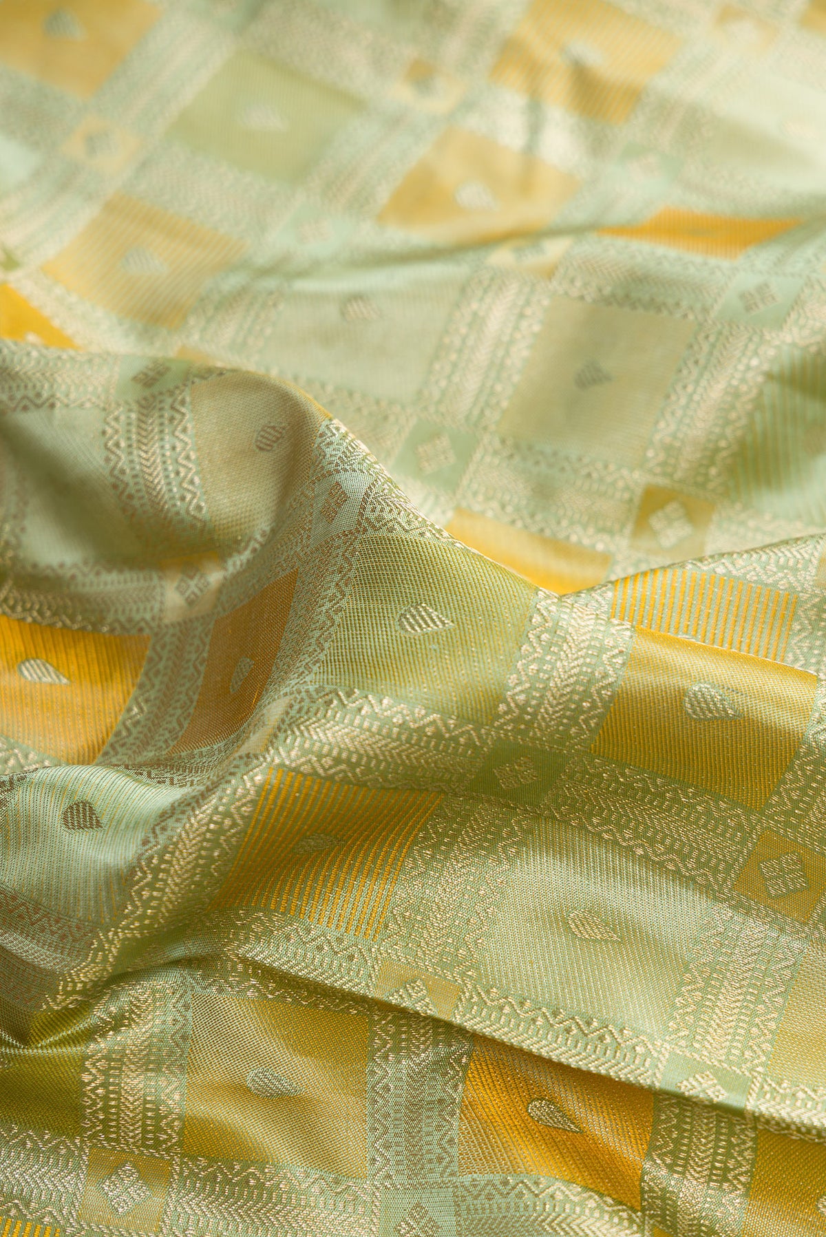 Close up of Pure Silk Pista Green Kanjivaram Saree with Zari Brocade on the body and Zari Border.  displaying folds