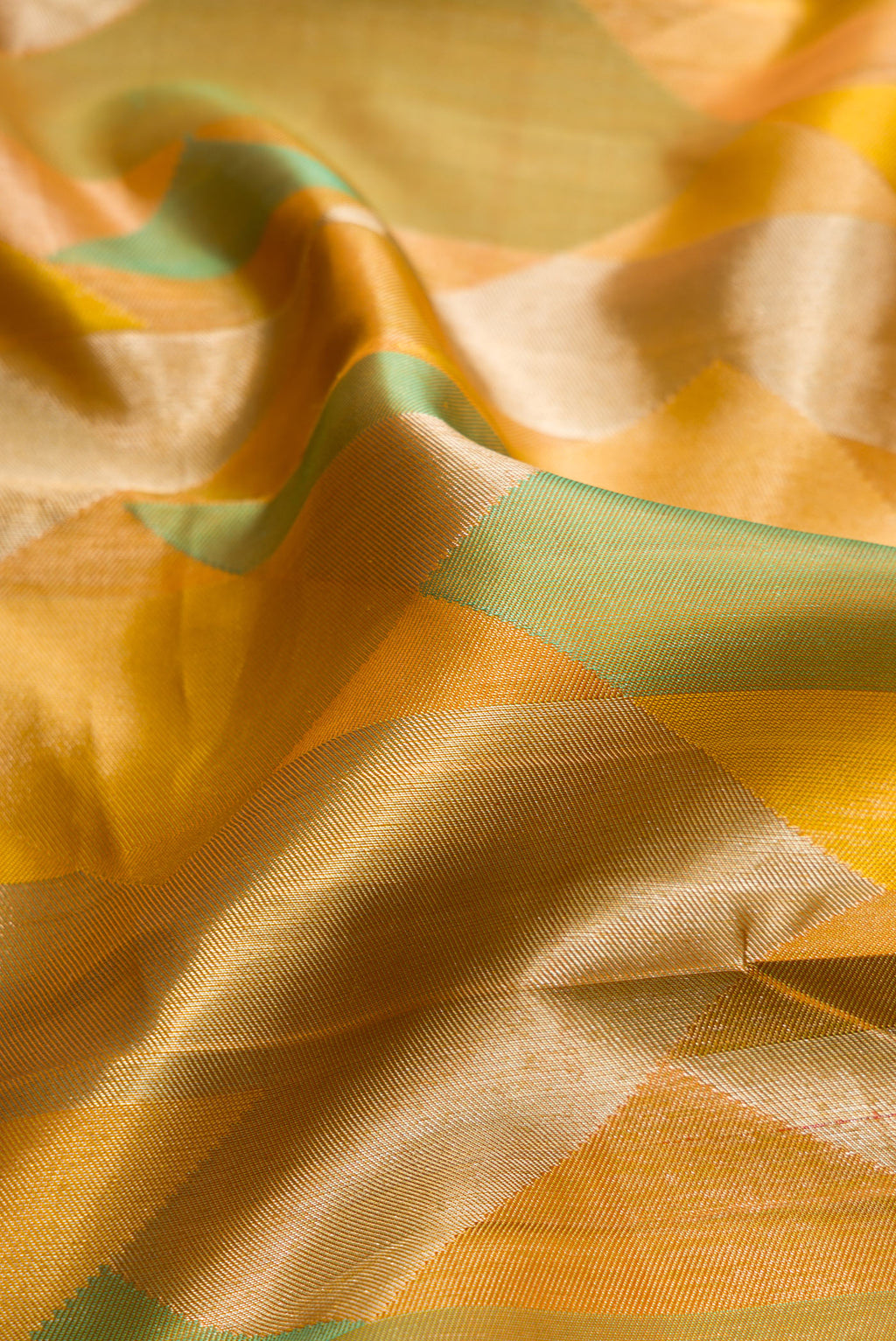 Close up of Pure Silk Mustard Kanjivaram Saree with Zari Brocade on the body and Without Border.  displaying folds