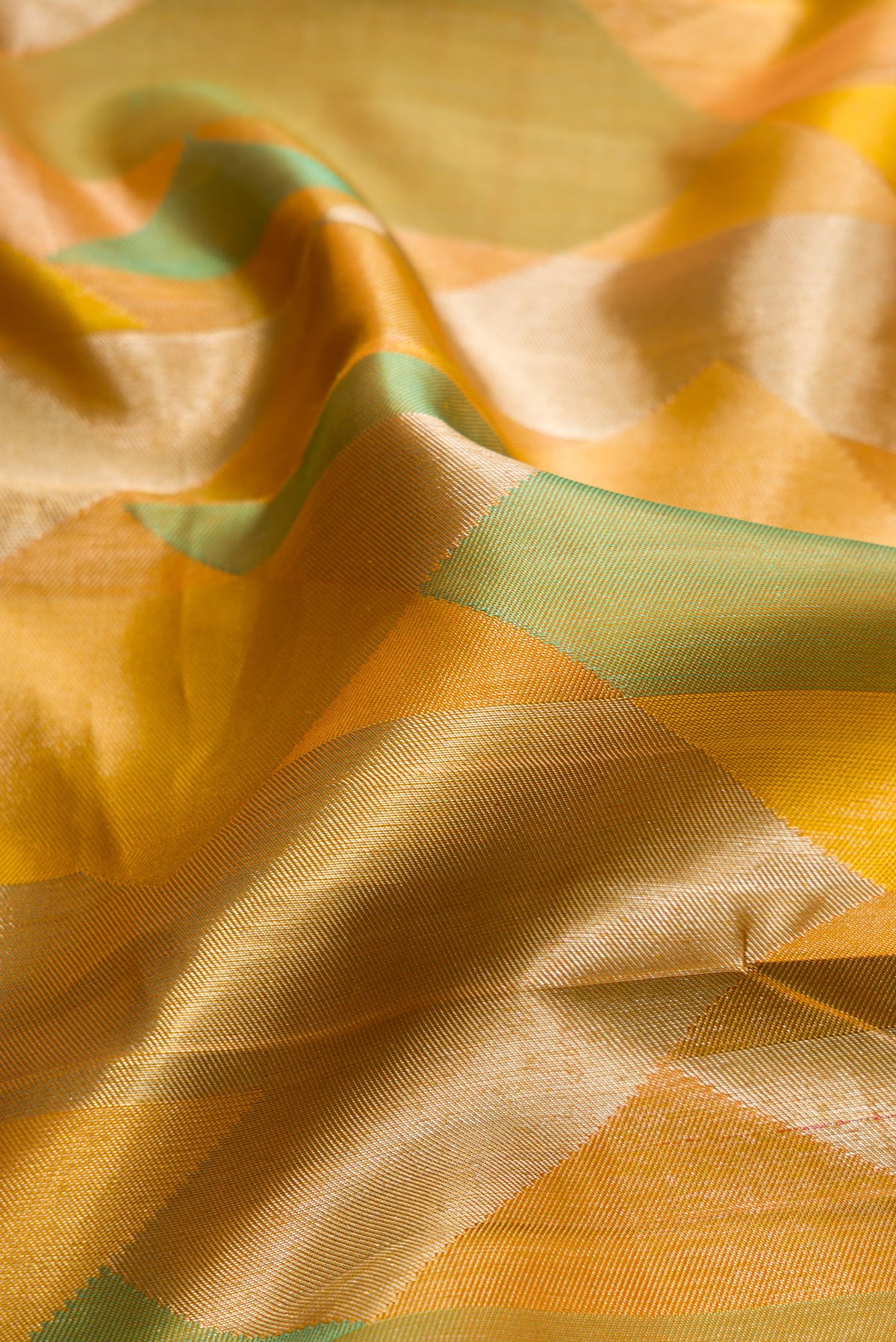 Close up of Pure Silk Mustard Kanjivaram Saree with Zari Brocade on the body and Without Border.  displaying folds