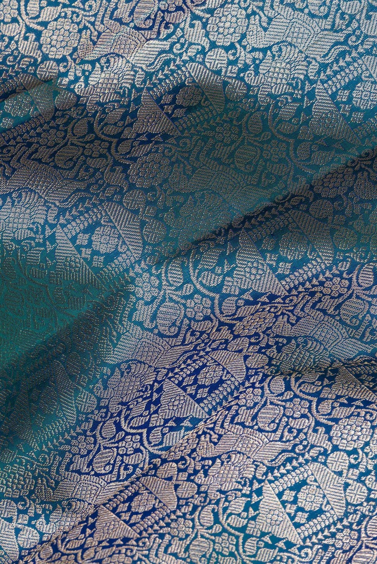 Close up of Pure Silk Peacock Blue Dual Tone Kanjivaram Saree with Zari Brocade on the body and Zari Border.  displaying folds