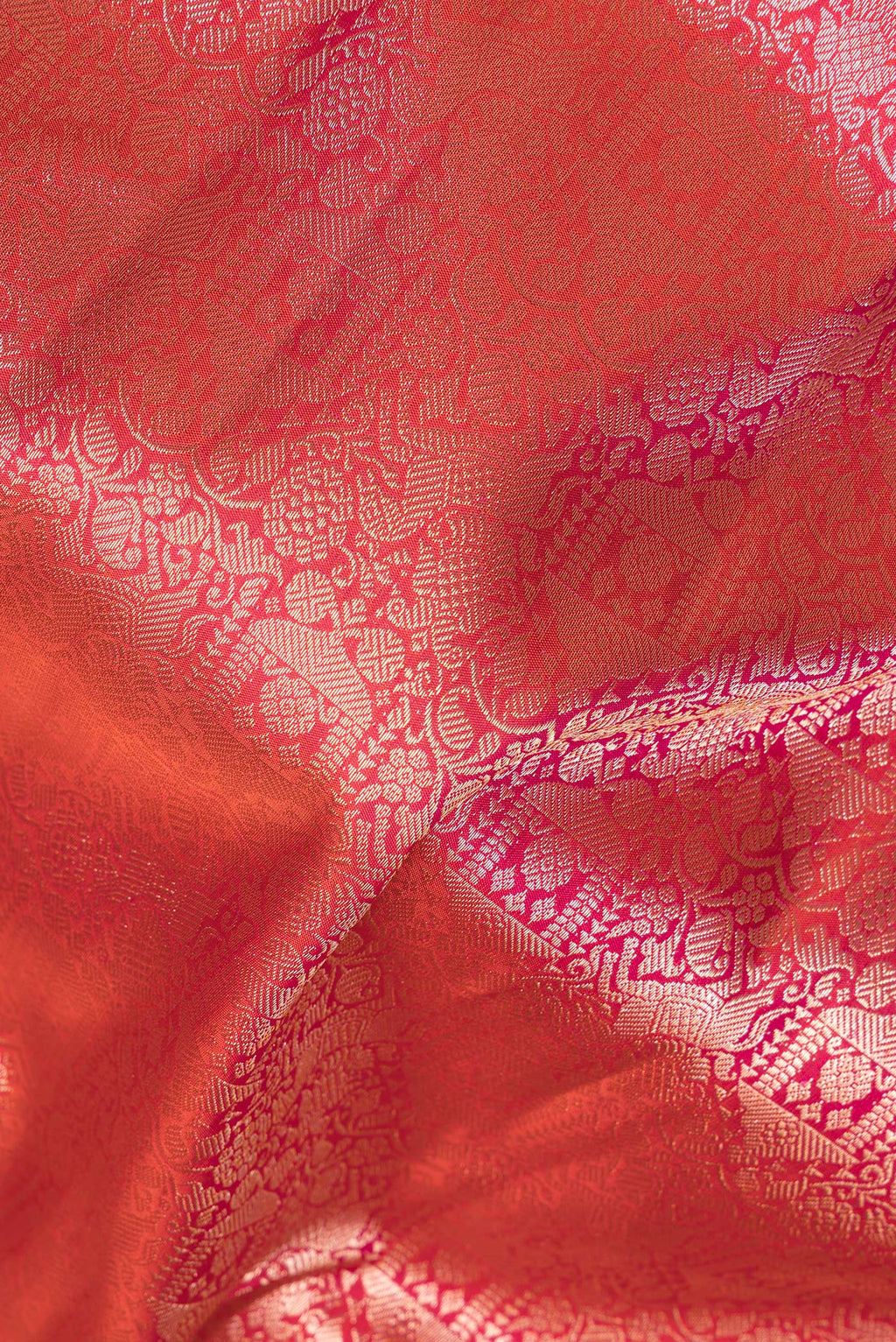 Close up of Pure Silk Brick Orange Dual Tone Kanjivaram Saree with Zari Brocade on the body and Fancy Border.  displaying folds