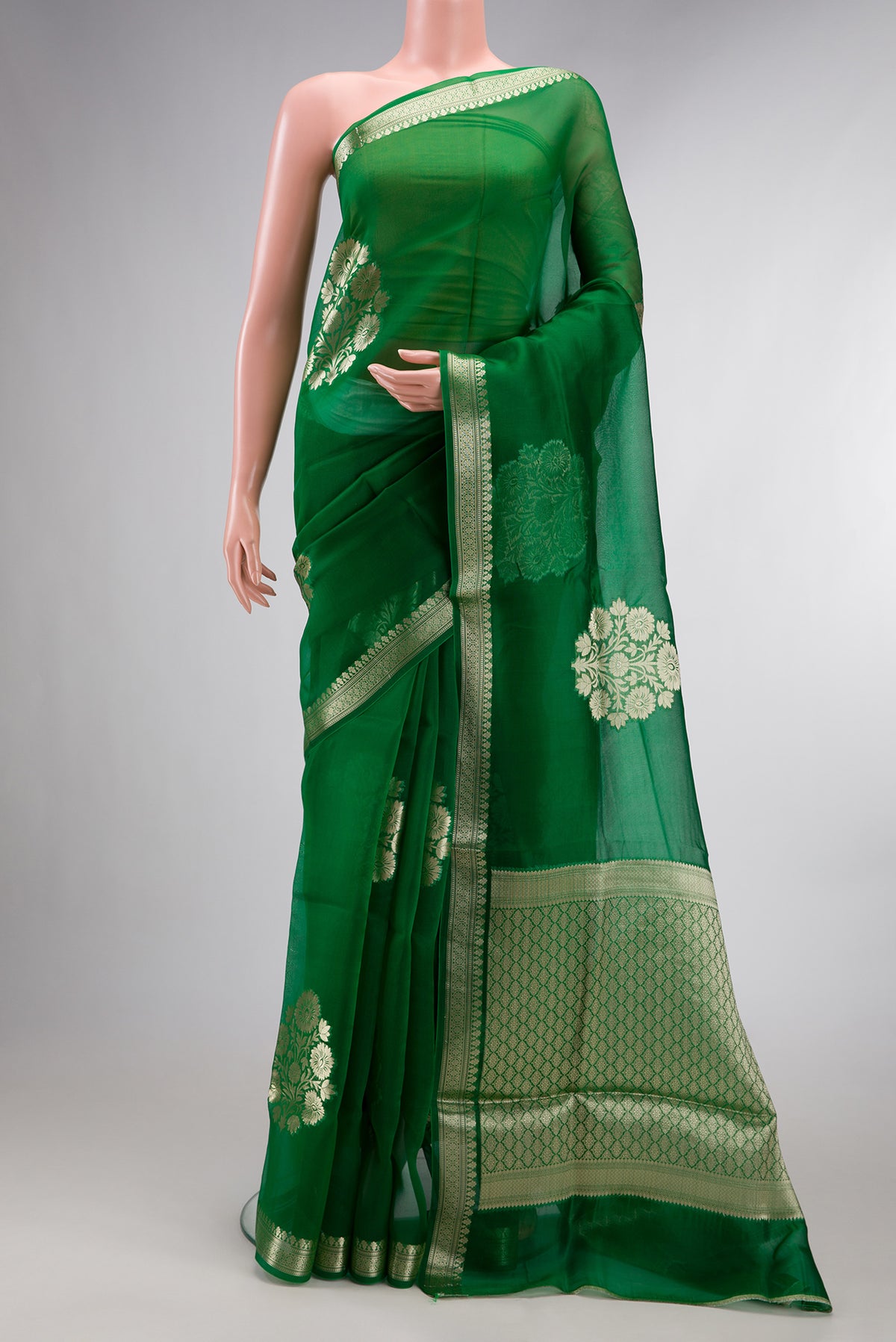 Green Organza Saree with Zari Butta on the body and Zari Border.  displayed on a mannequin