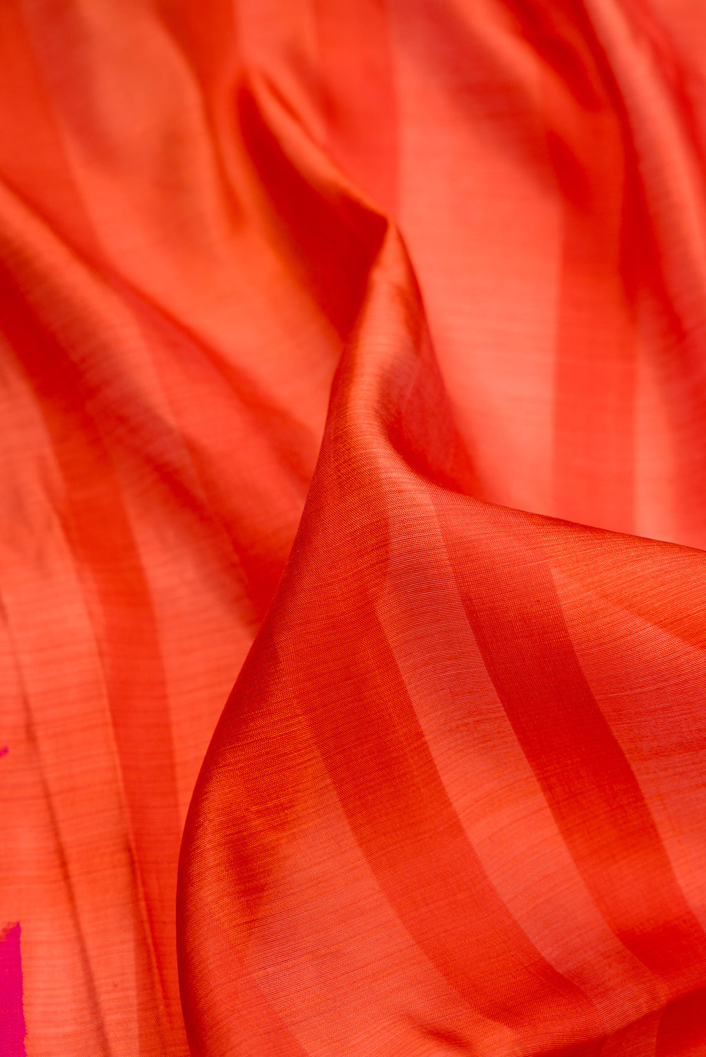 Close up of Orange Tussar Saree with Stripes on the body and Fancy Border.  displaying folds