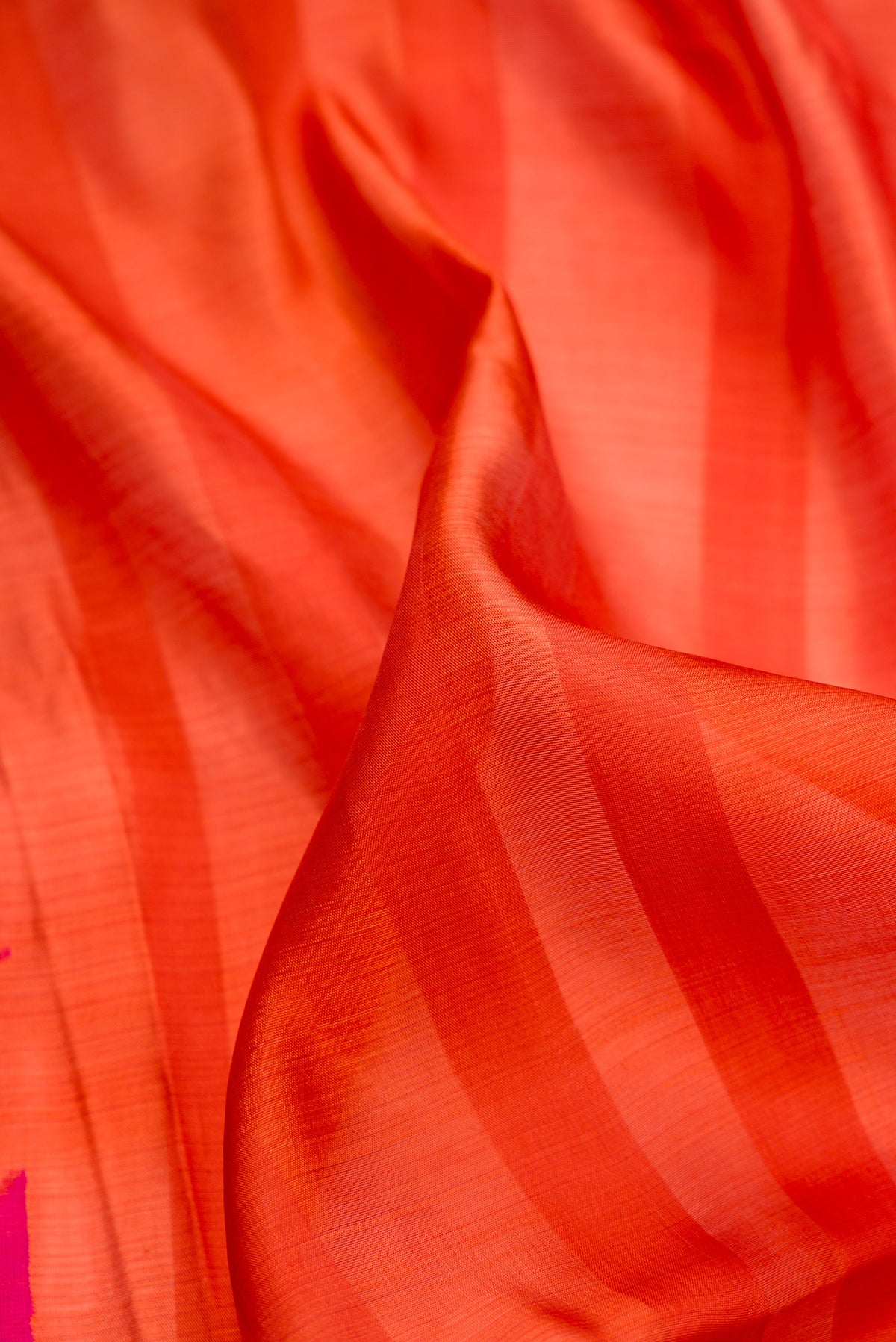 Close up of Orange Tussar Saree with Stripes on the body and Fancy Border.  displaying folds