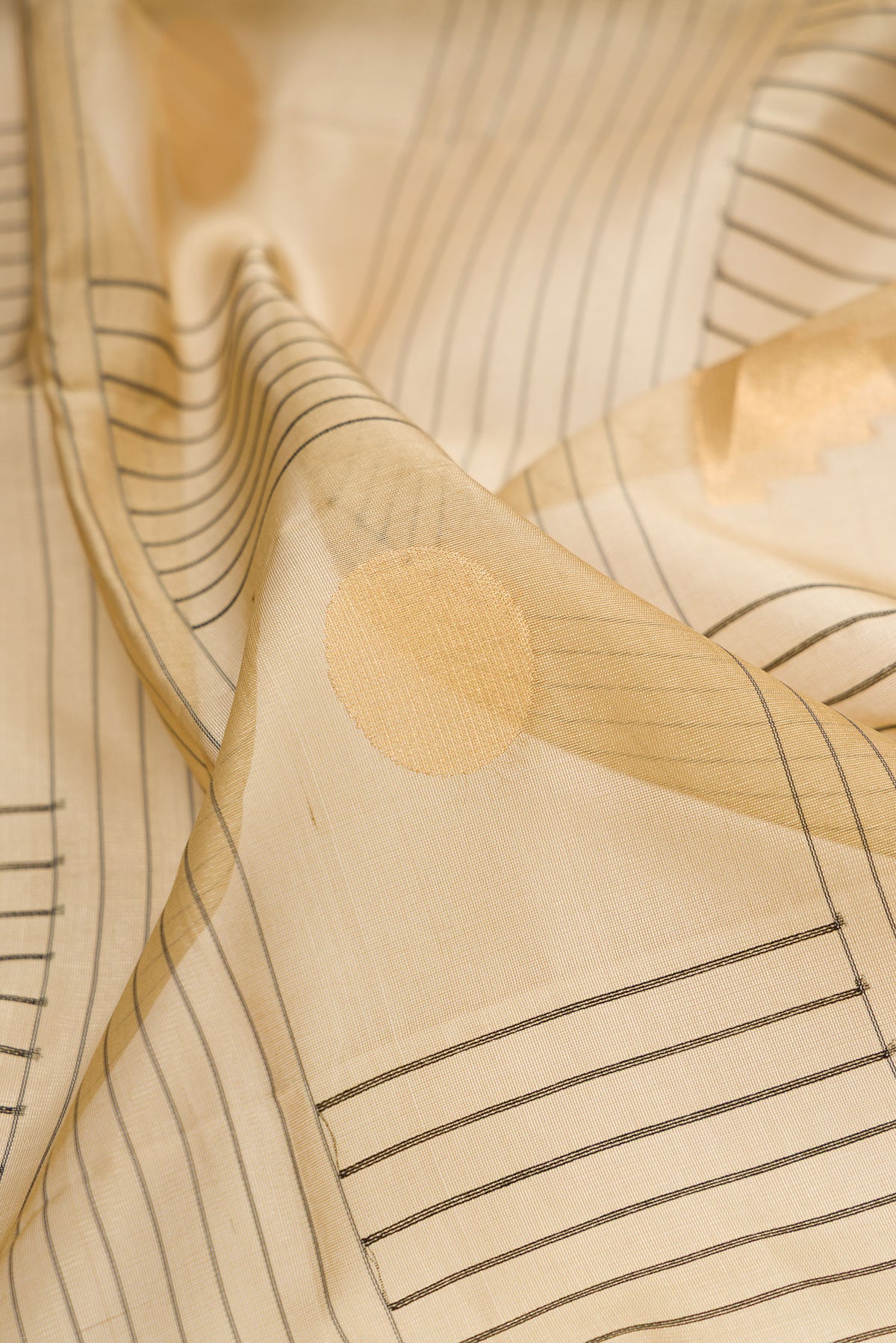 Close up of Pure Silk Beige Soft Saree with Checked design on the body and Zari Border.  displaying folds